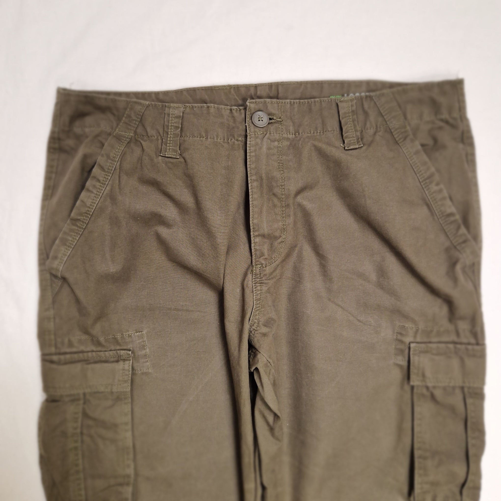 A pair of olive green cargo pants laid flat on a white background, showing the front waistband, button closure, belt loops, and side cargo pockets.