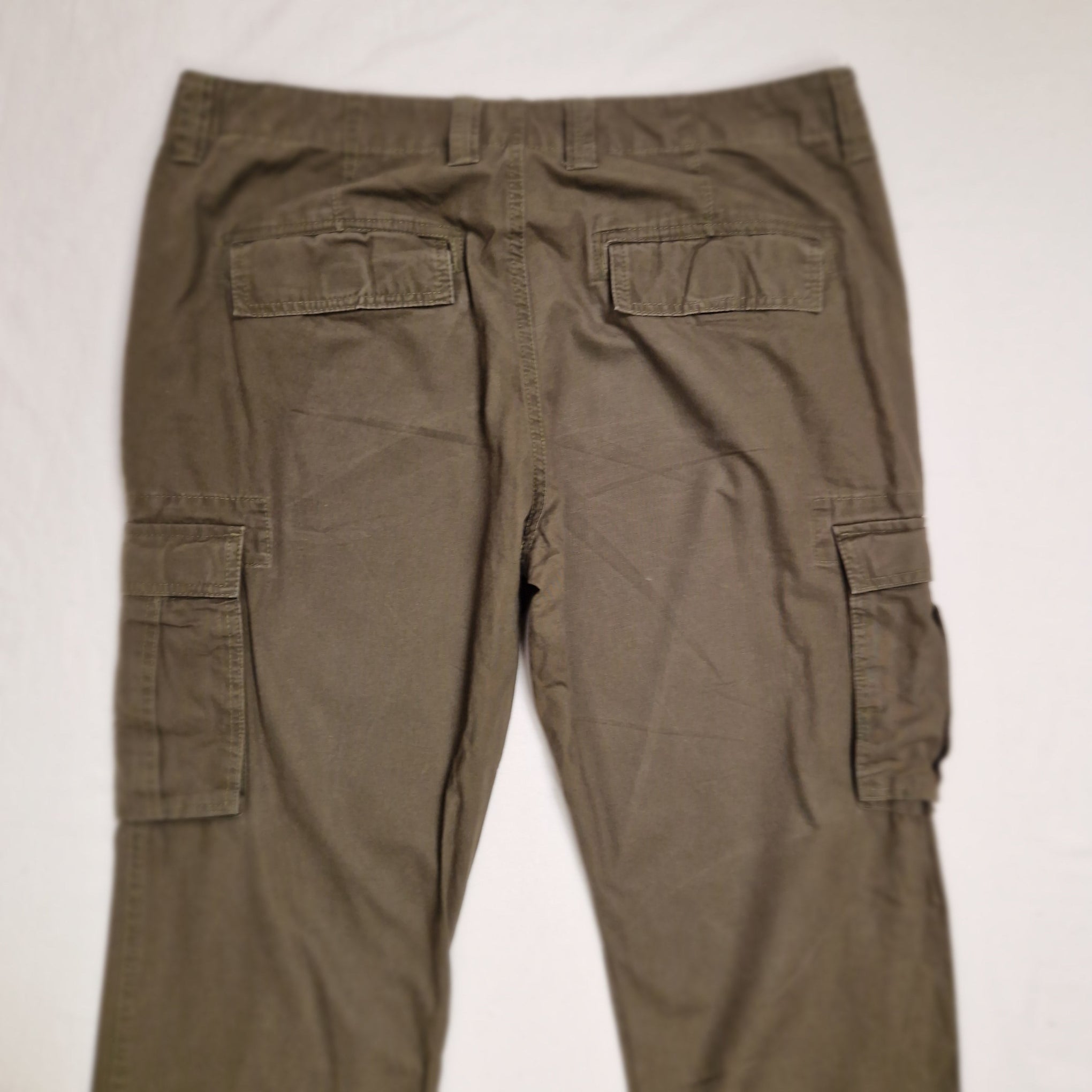 A pair of olive green cargo pants laid flat on a white background, showing the back pockets and waistband.