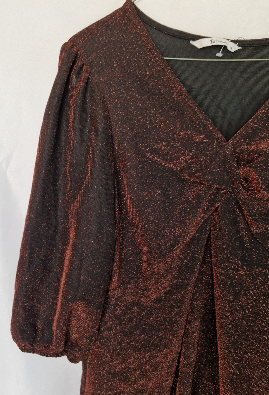A maroon long-sleeve V-neck top with a glitter finish and a twist front detail.