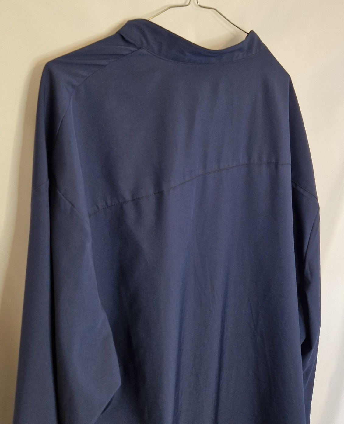 A blue long-sleeve shirt in a smooth satin fabric with a subtle contrast trim detail.