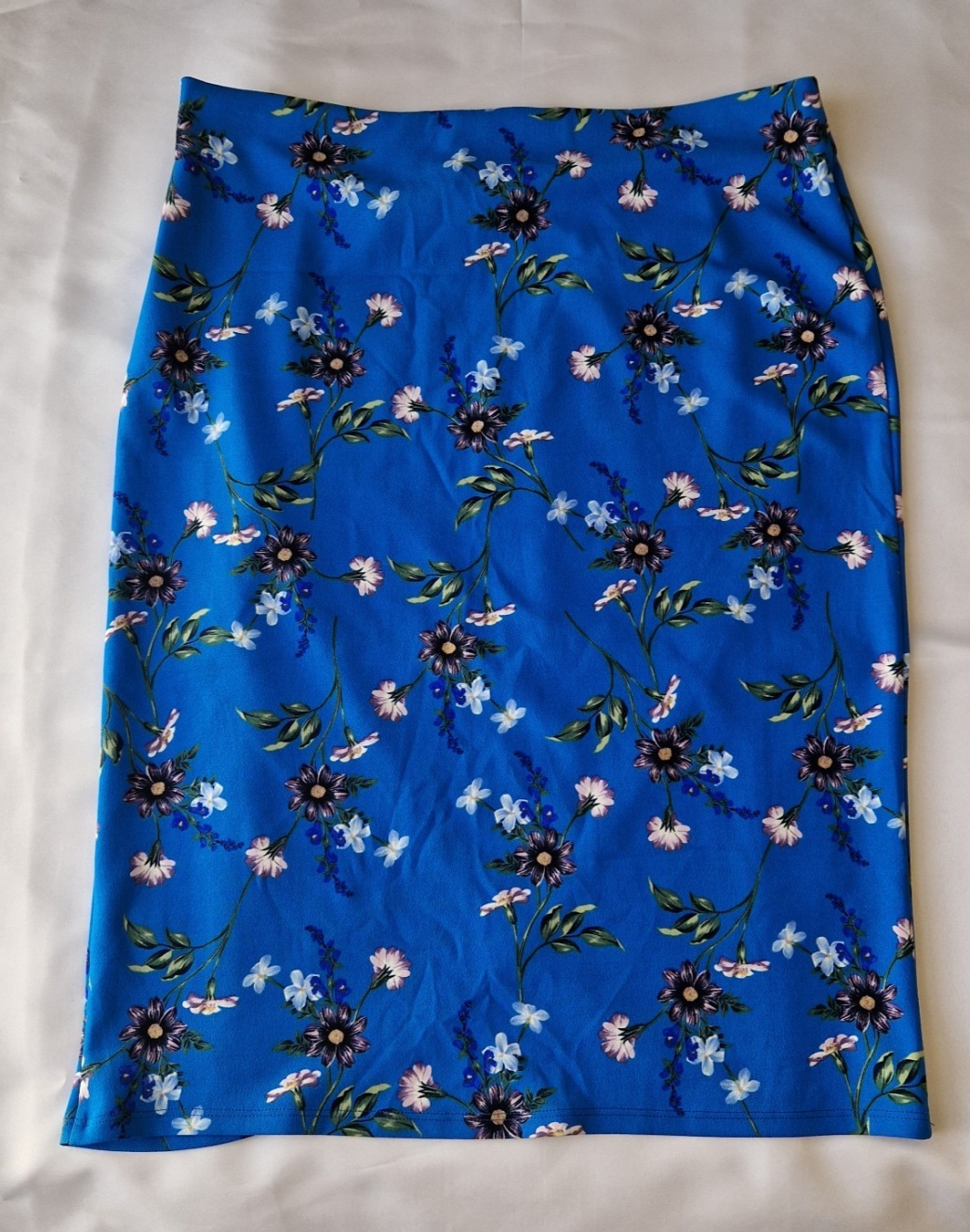 A blue knee-length wrap skirt featuring a floral print in a stretch jersey fabric.