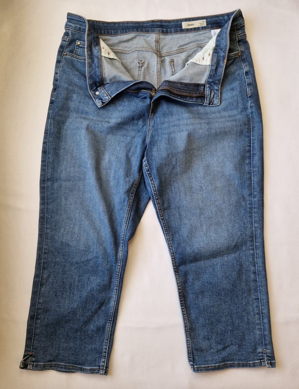 Marks and Spencer mid-rise blue skinny jeans with a zip fly and five-pocket design.