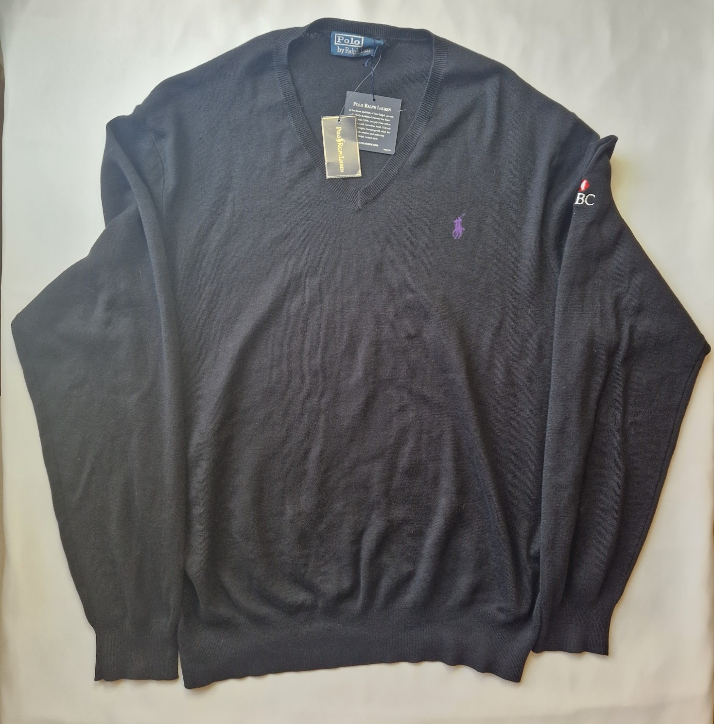 A black long-sleeved V-neck cotton sweater by Polo Ralph Lauren with an embroidered HSBC logo.