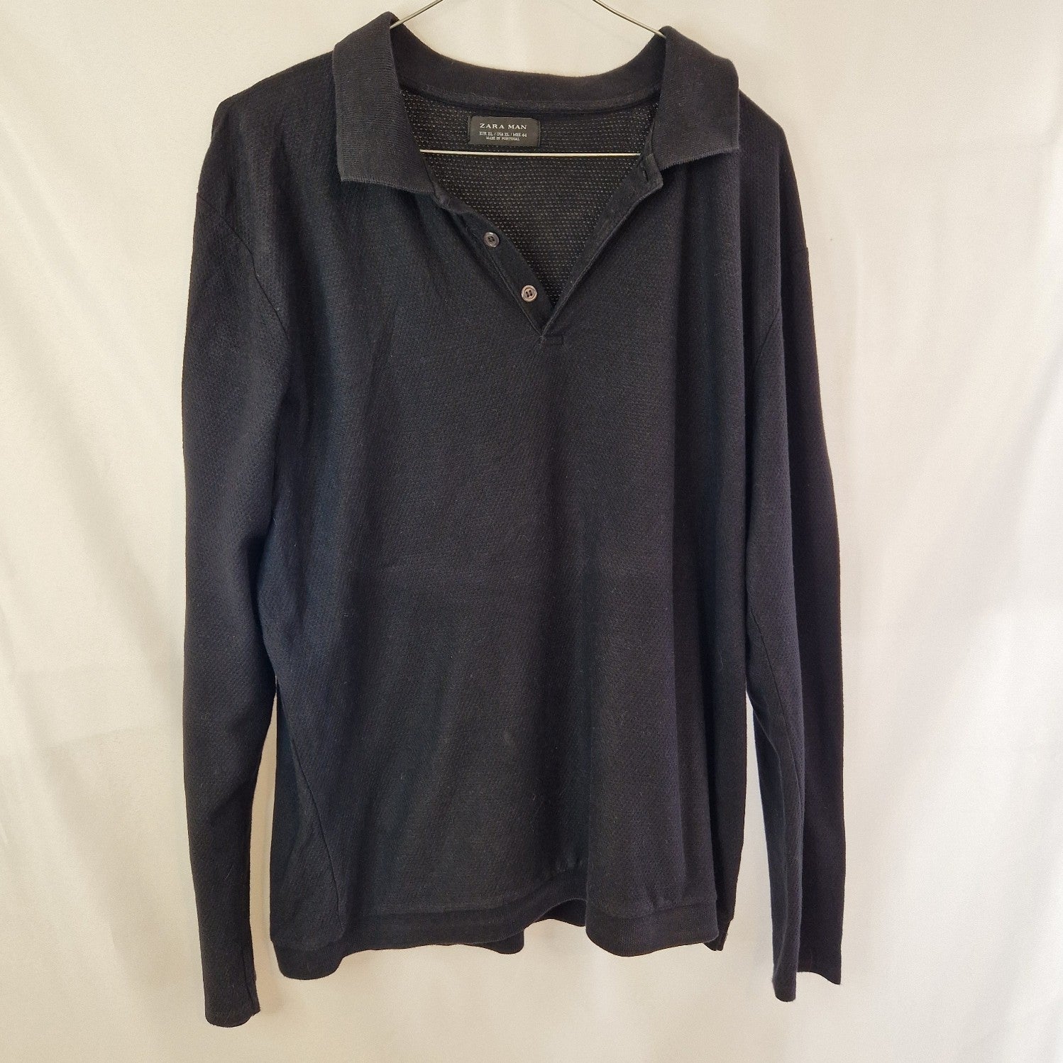 A black Zara Man long-sleeve knit sweater with a collared neckline and two-button placket.