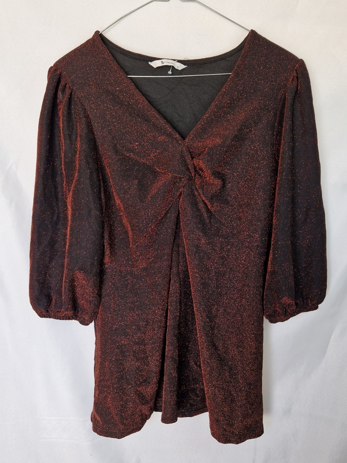 A maroon long-sleeve V-neck top with a glitter finish and a twist front detail.