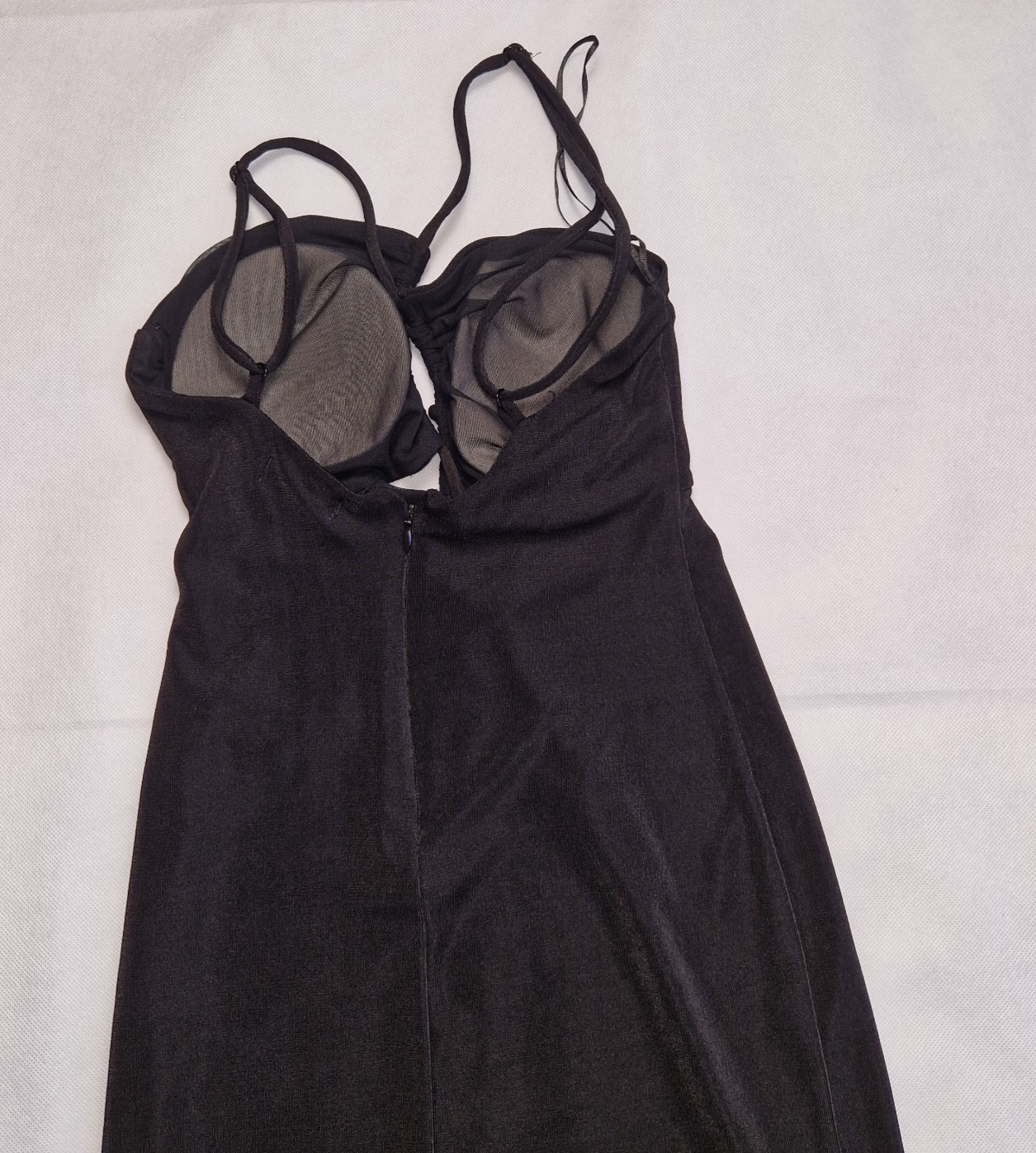 A black Bershka off-shoulder crop top with integrated padding and thin strappy sleeves.