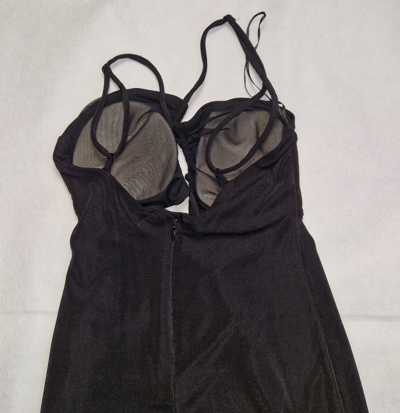 A black Bershka off-shoulder crop top featuring integrated padding and thin strappy sleeves.