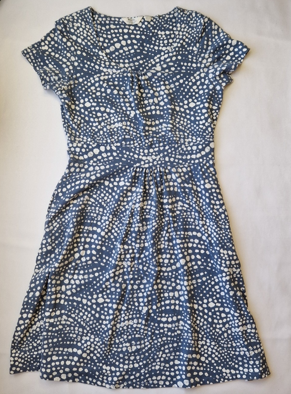 A blue knee-length fit and flare dress with a white polka dot pattern and short cap sleeves.