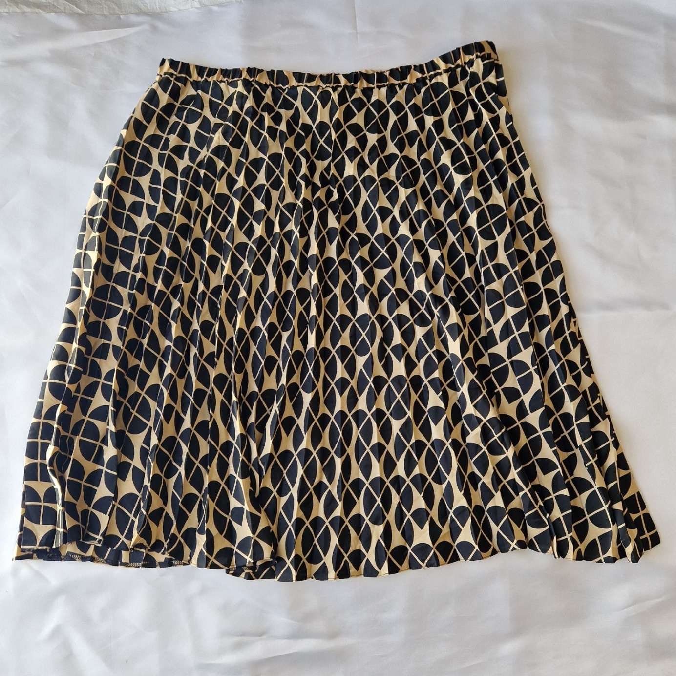 A metallic gold and black geometric print A-line skirt with an elasticated high-rise waist.