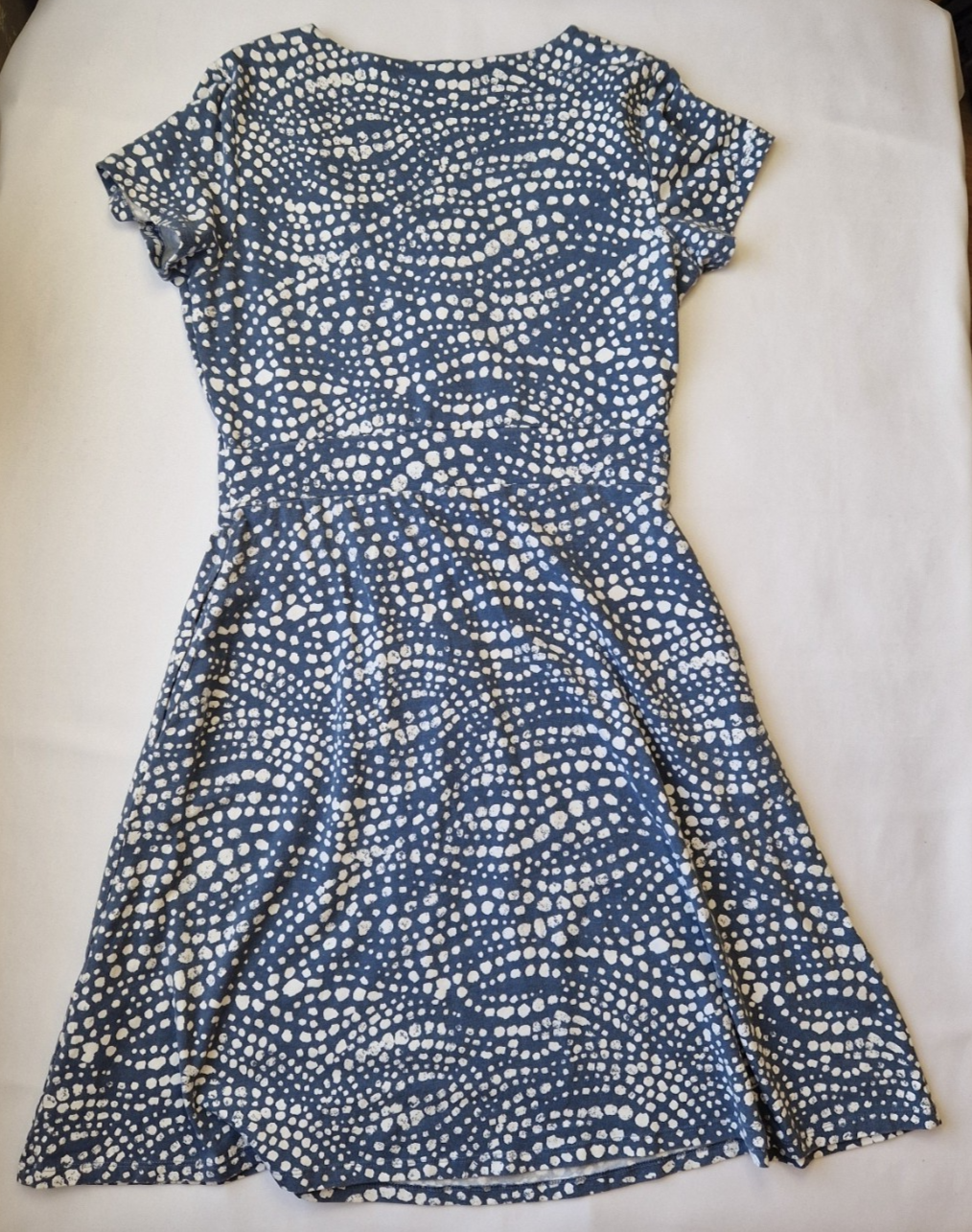 A blue knee-length fit and flare dress with short cap sleeves and a white polka dot pattern.