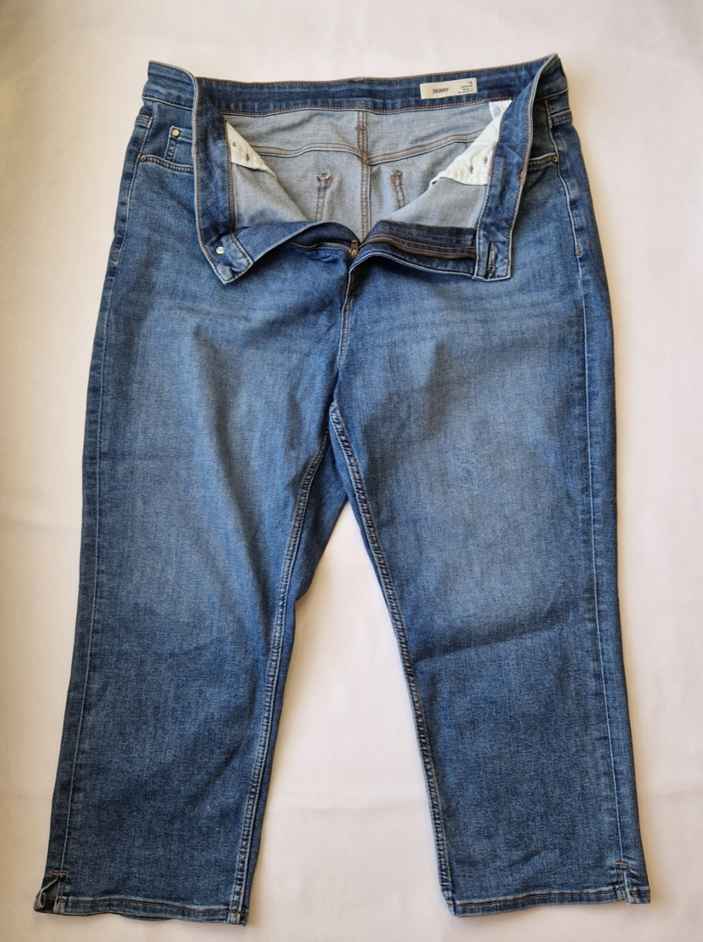 Marks and Spencer mid-rise blue stretch skinny jeans with a zip fly and five-pocket design.
