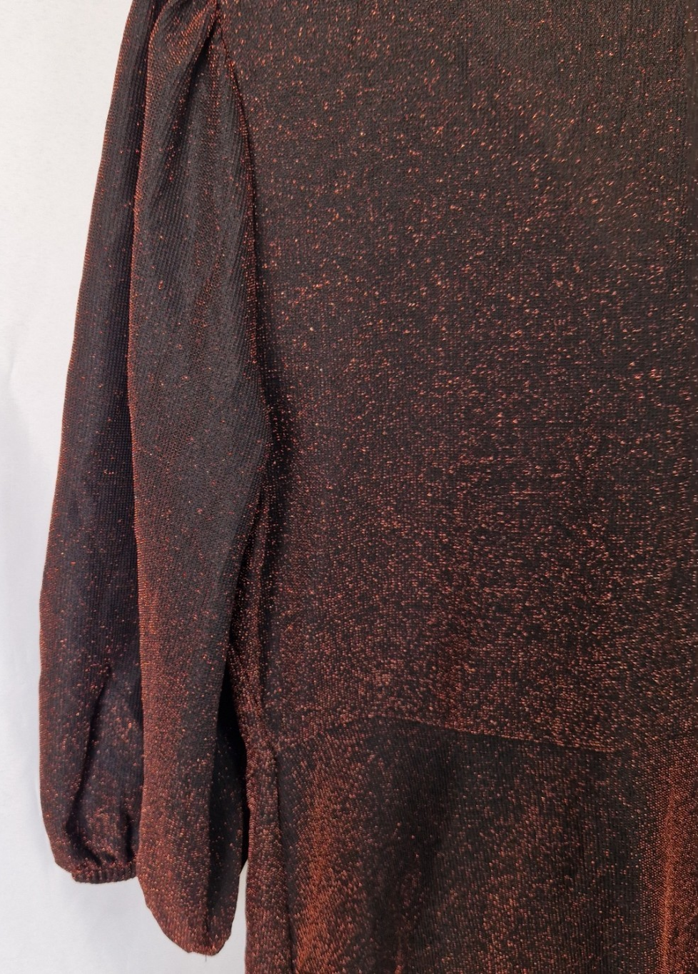 A maroon long-sleeve top with a subtle glitter finish and gathered shoulder detail.