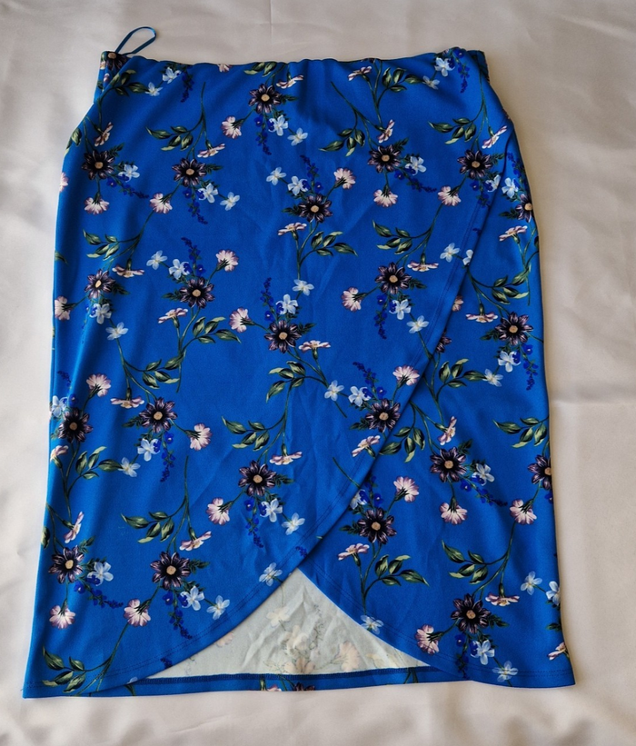 A blue knee-length wrap skirt in stretch jersey featuring a floral print.