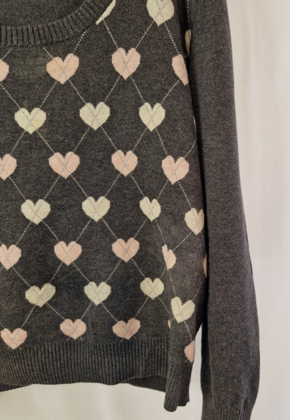 A grey Papaya long-sleeve jumper featuring a repeating white and pink heart pattern.