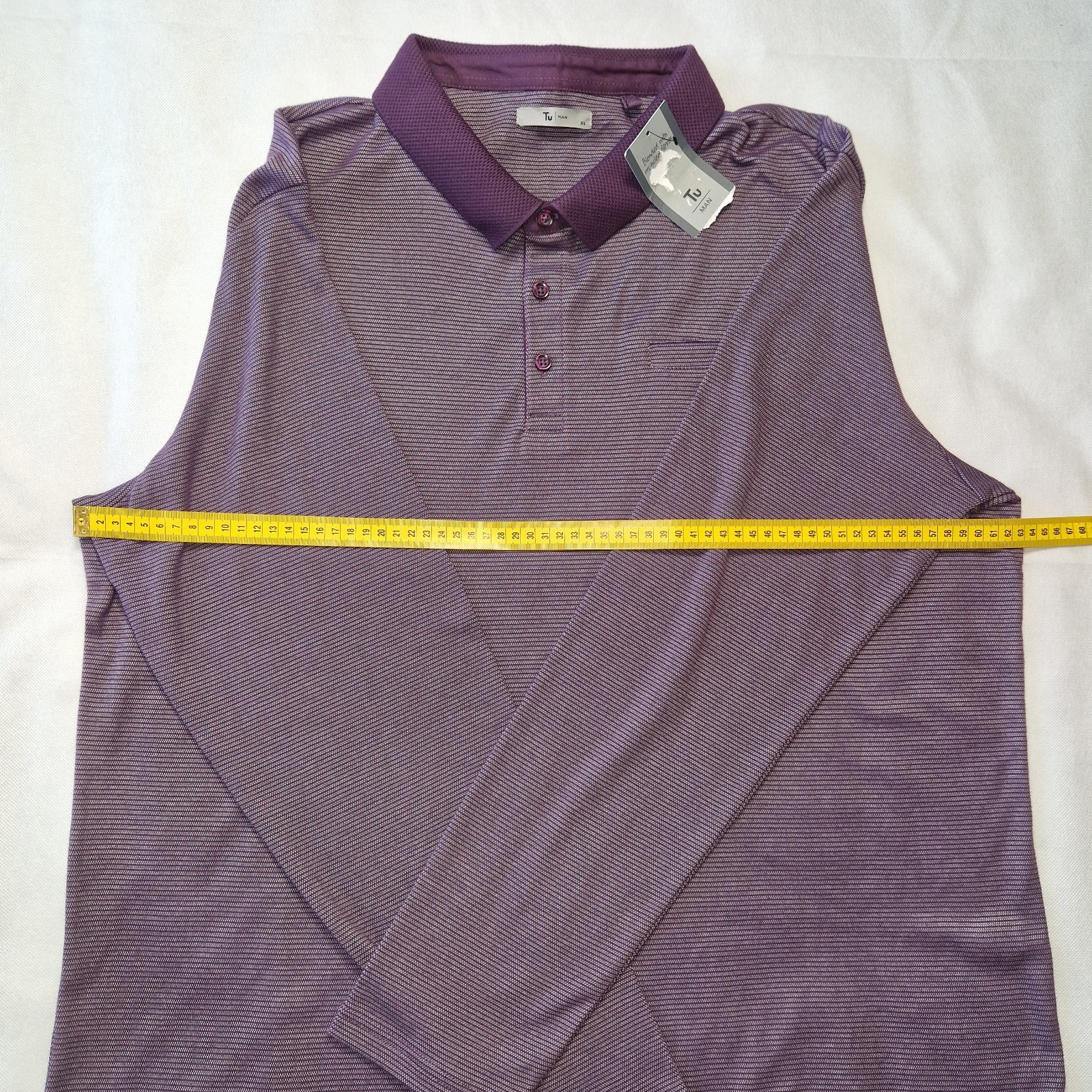 A purple long-sleeved Tu Man pullover sweatshirt with a collared neckline and a measuring tape.