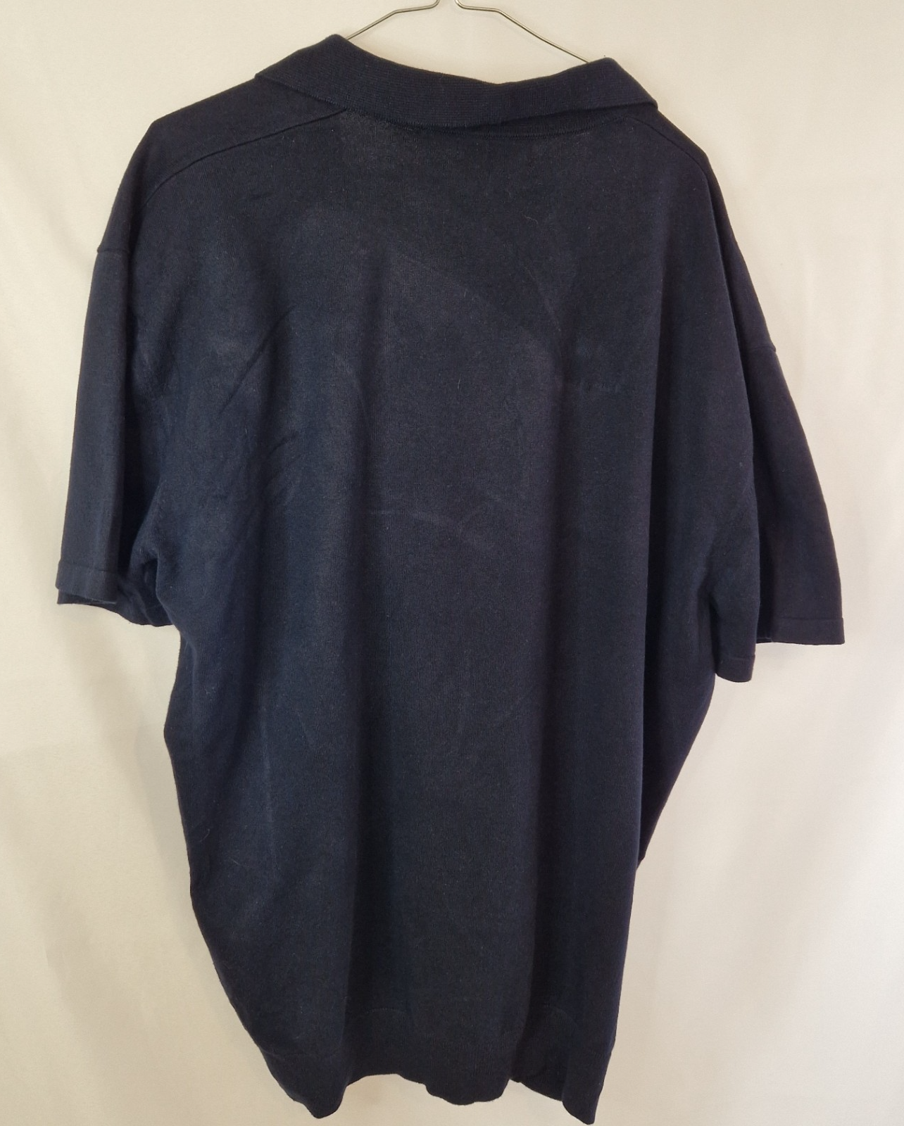 A dark blue Next short-sleeve polo shirt with a V-neck collar in a regular fit.