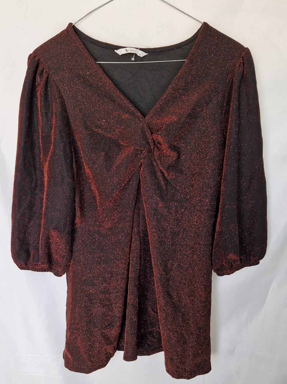 A maroon long-sleeve top with a V-neck, glitter finish, and a twist-front detail.