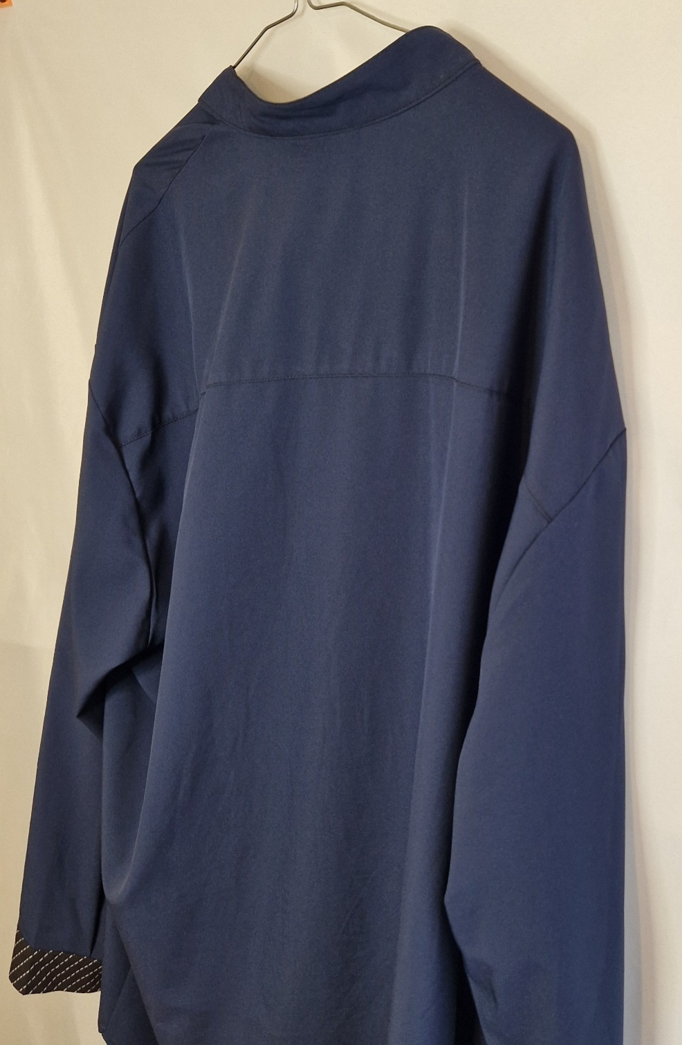 A blue long-sleeve shirt with a mock neck and contrast trim on the cuffs.
