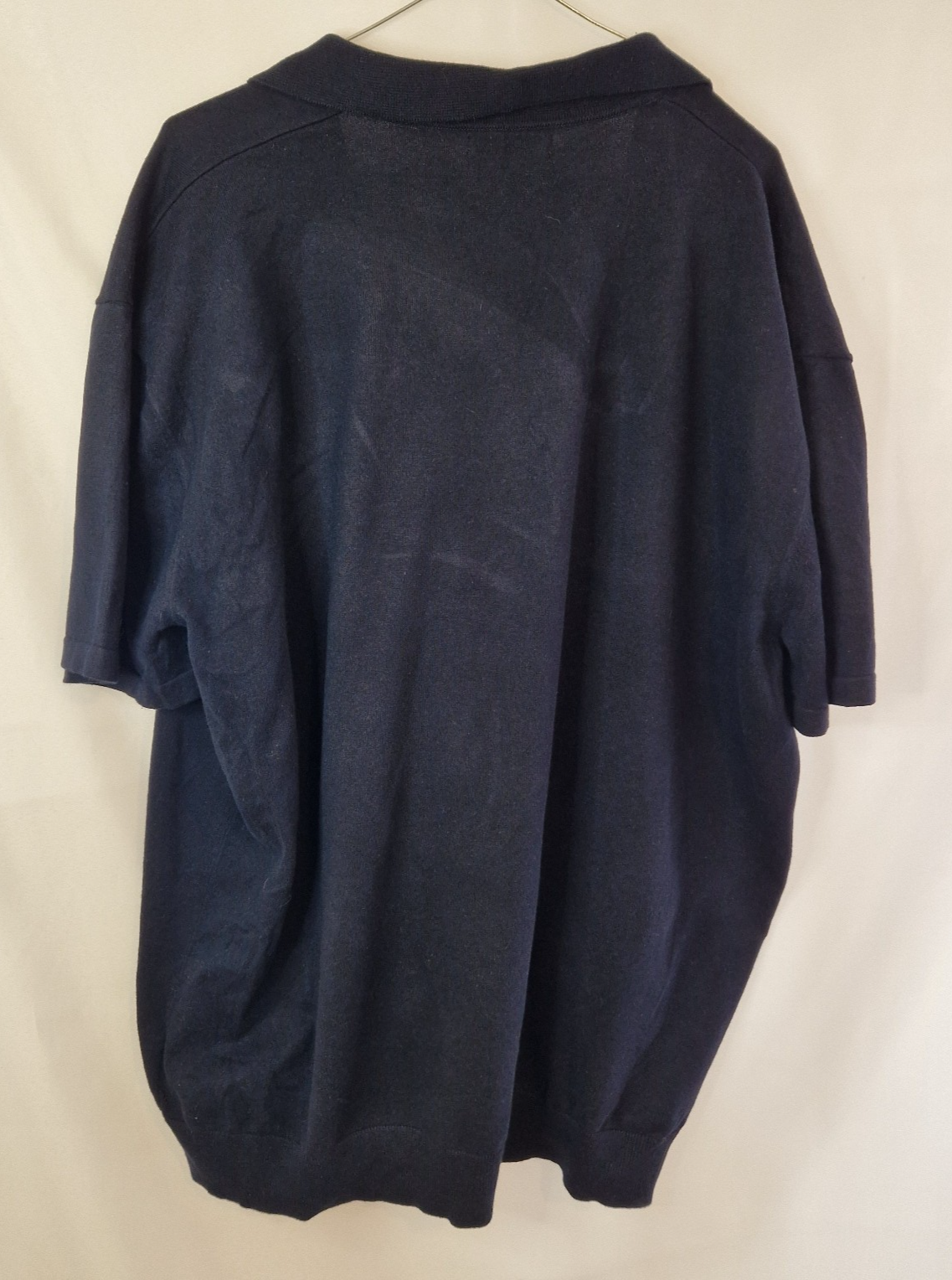 A dark blue Next men's short-sleeve cotton polo shirt with a V-neck collar.
