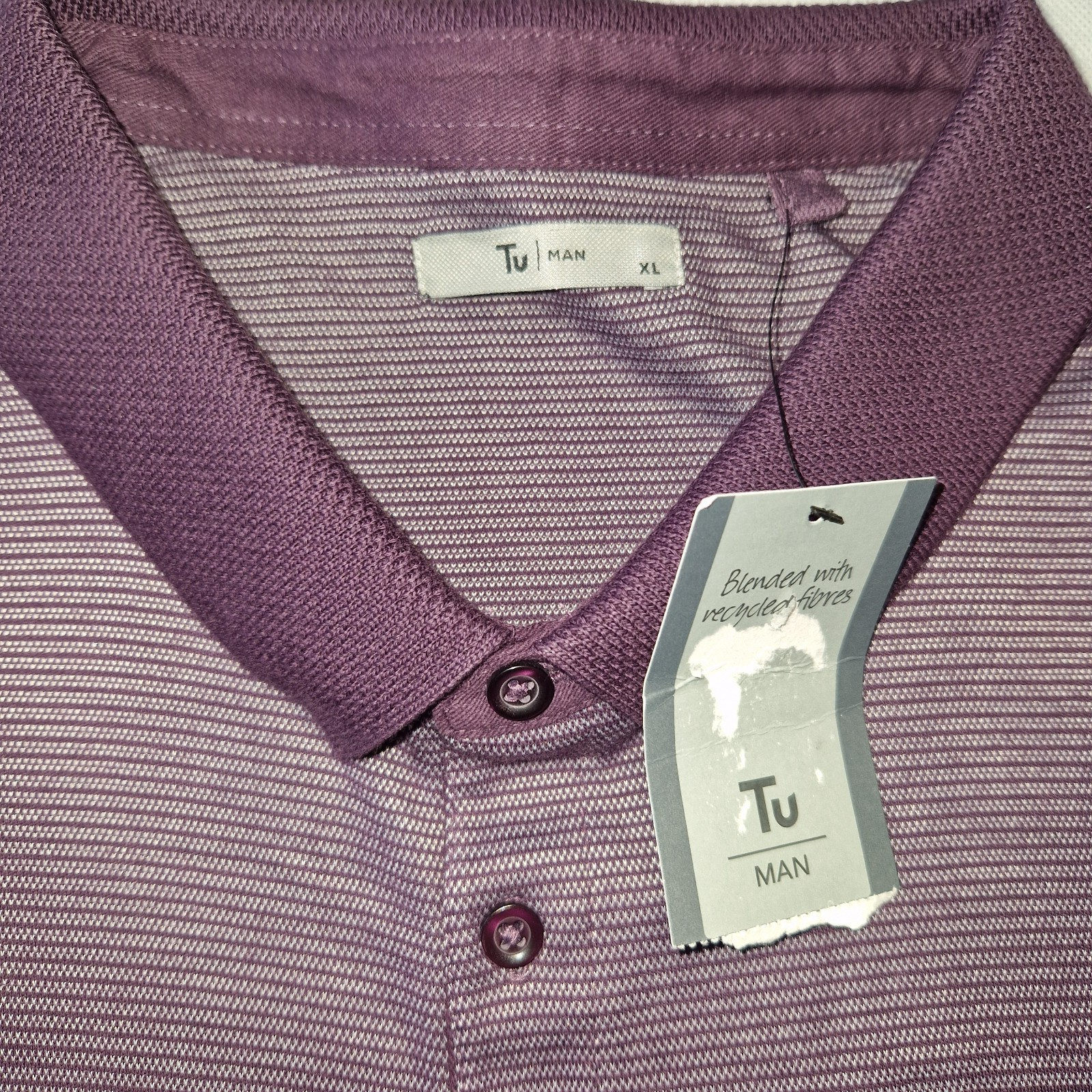 A purple, textured, short-sleeved polo shirt with a collar and button placket by Tu Man.