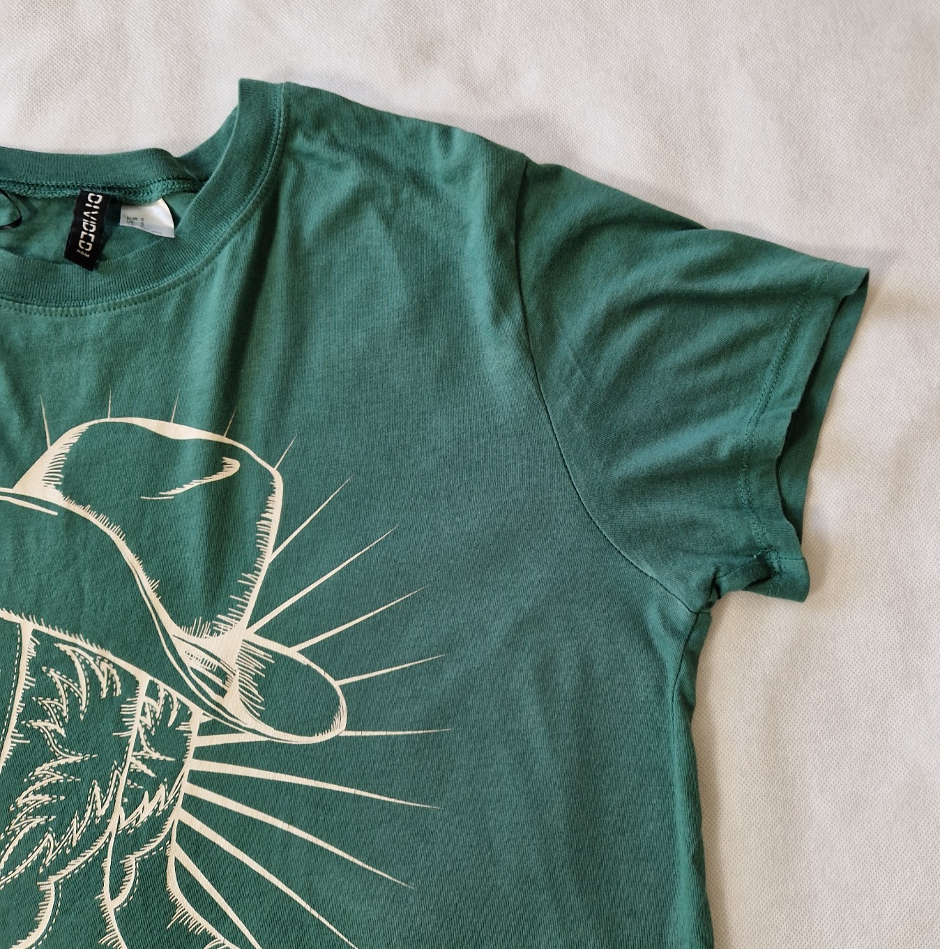 A green H&M Divided cotton t-shirt with a graphic print of a cowboy hat.