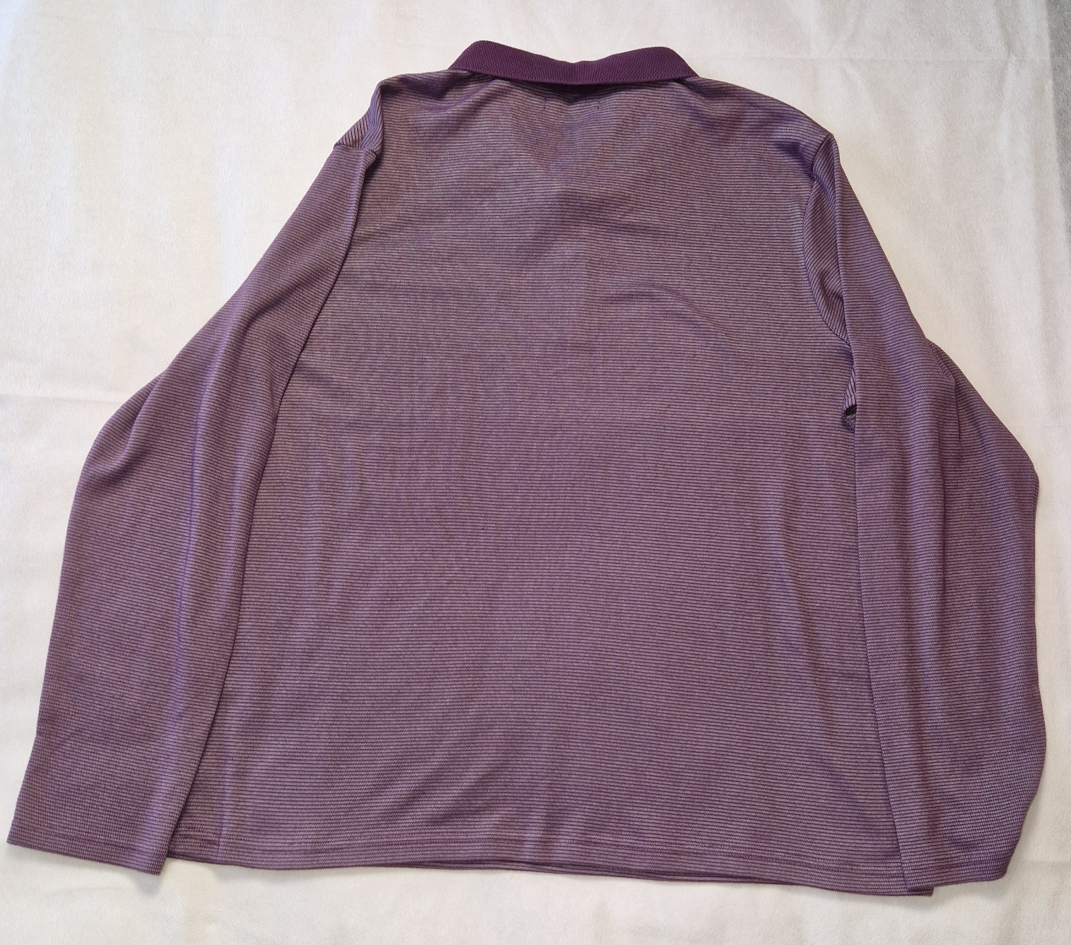 A purple long-sleeved pullover sweatshirt with a round neck in a soft cotton blend fabric.