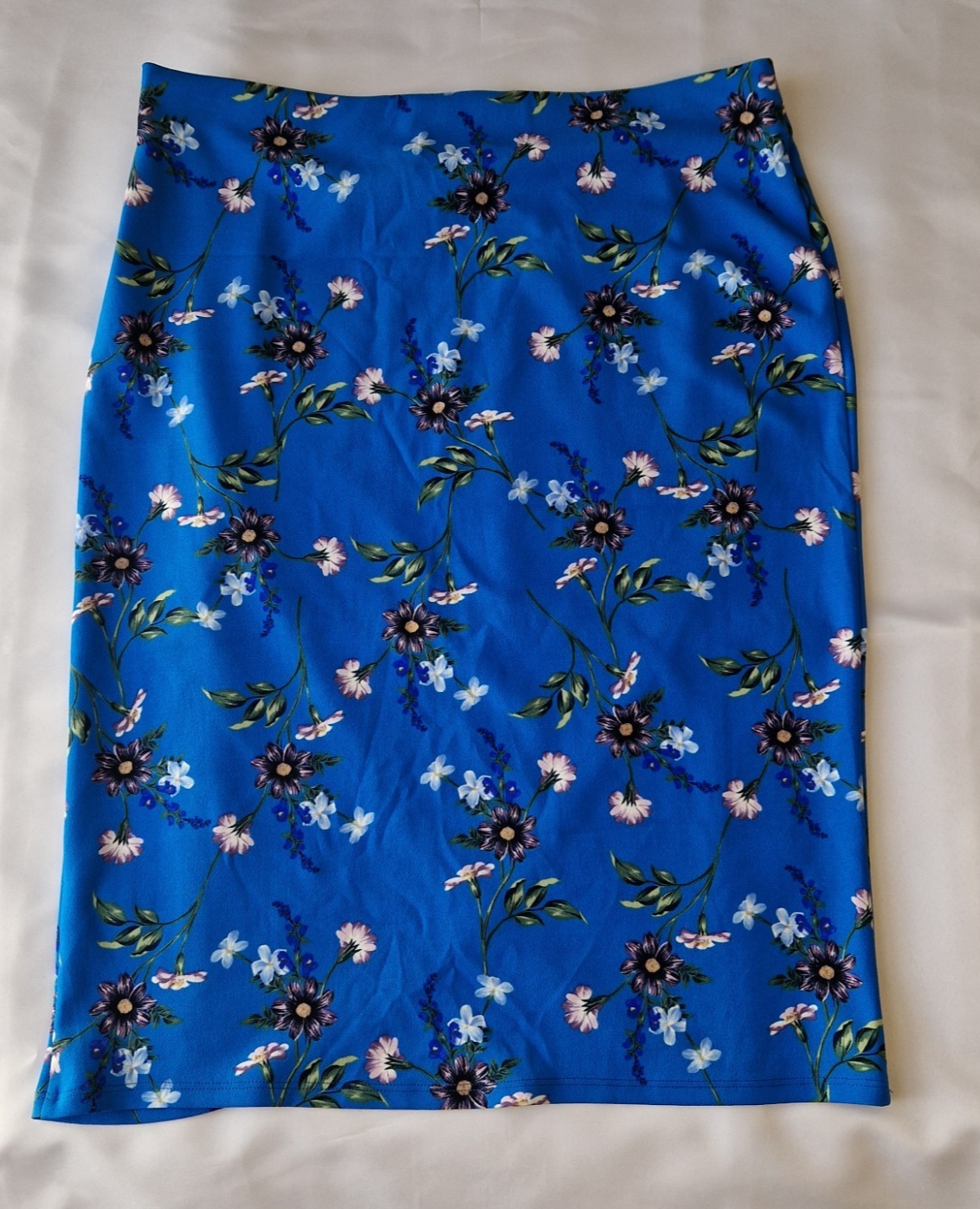 A blue knee-length wrap skirt in stretch jersey featuring a floral print pattern.