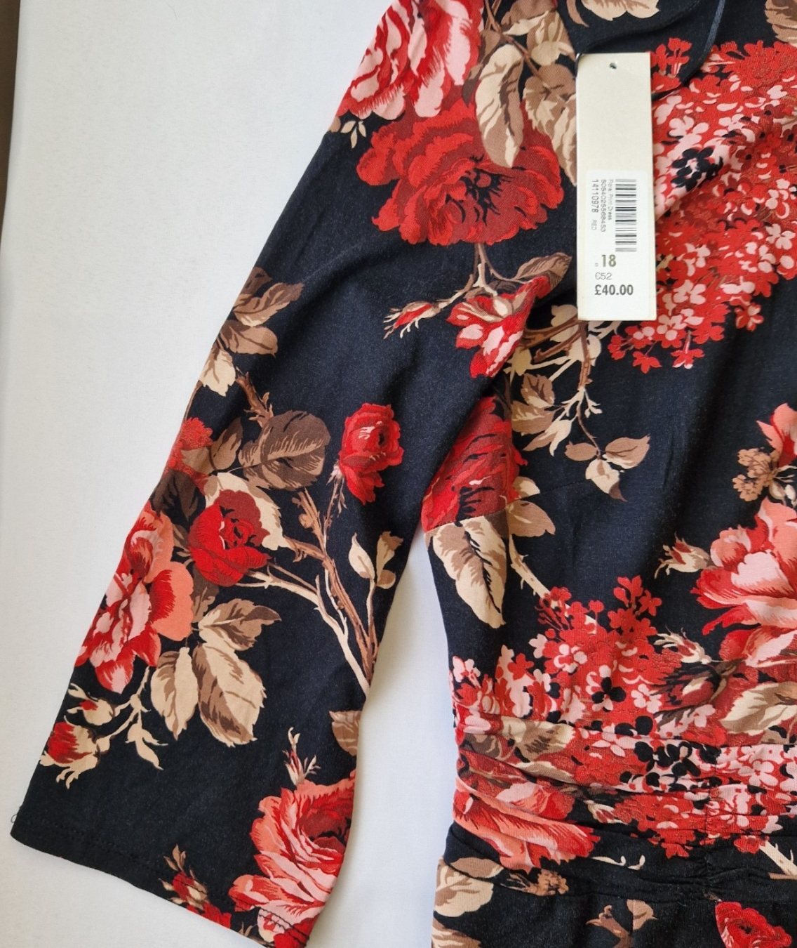 A black fit and flare dress featuring a vibrant red floral print and long flared sleeves.