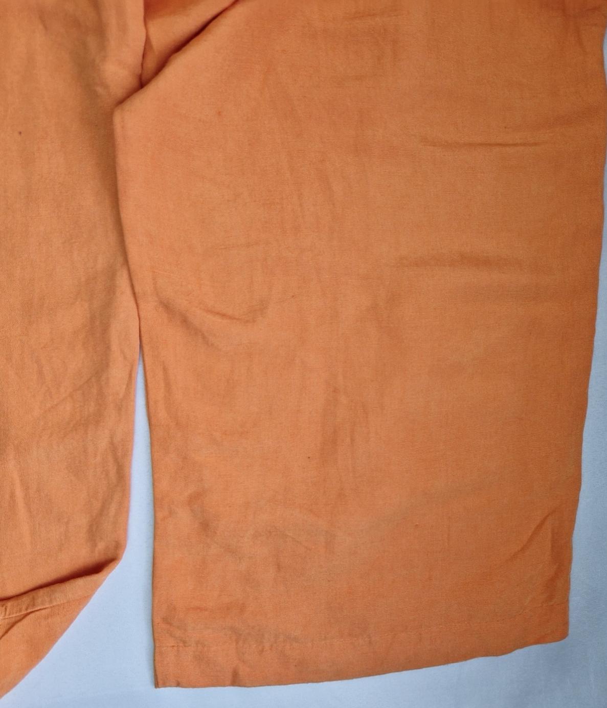 Close-up of orange H&M wide-leg jogger trousers in a linen-blend fabric.