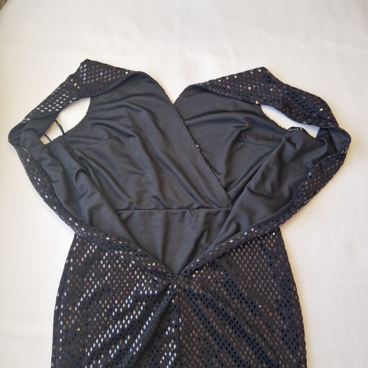 A black one-shoulder bodycon party dress featuring a sequin mesh overlay and full lining.