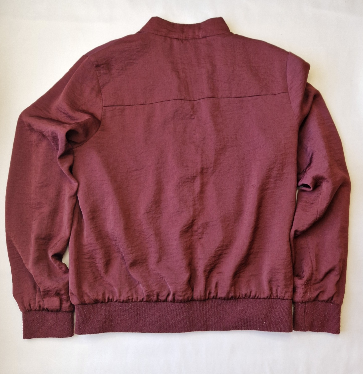 A maroon New Look lightweight bomber jacket with long sleeves and a ribbed hem.