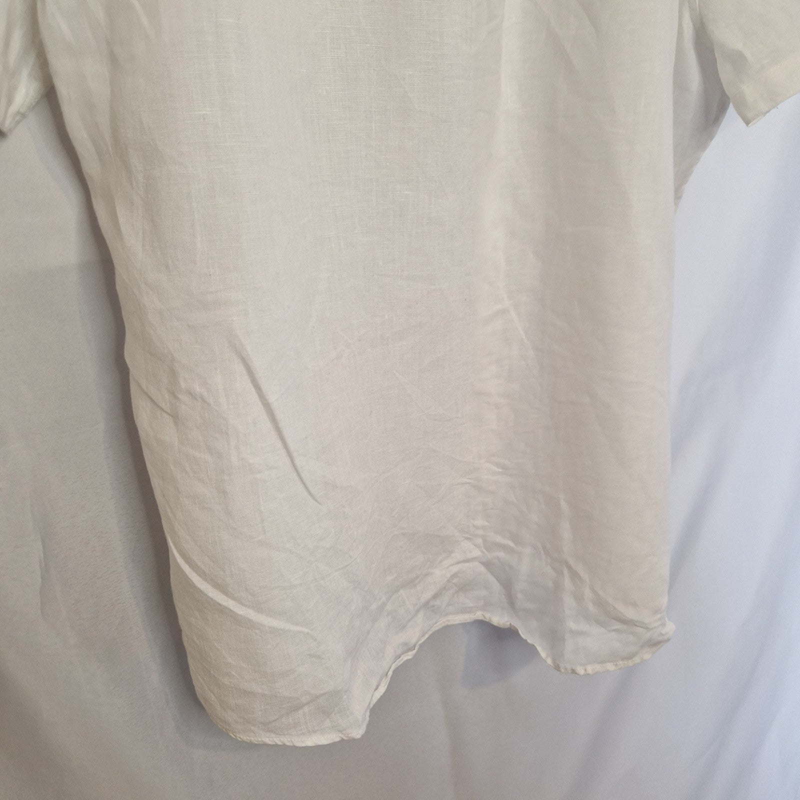 A white short-sleeved button-down shirt with a blue floral print.