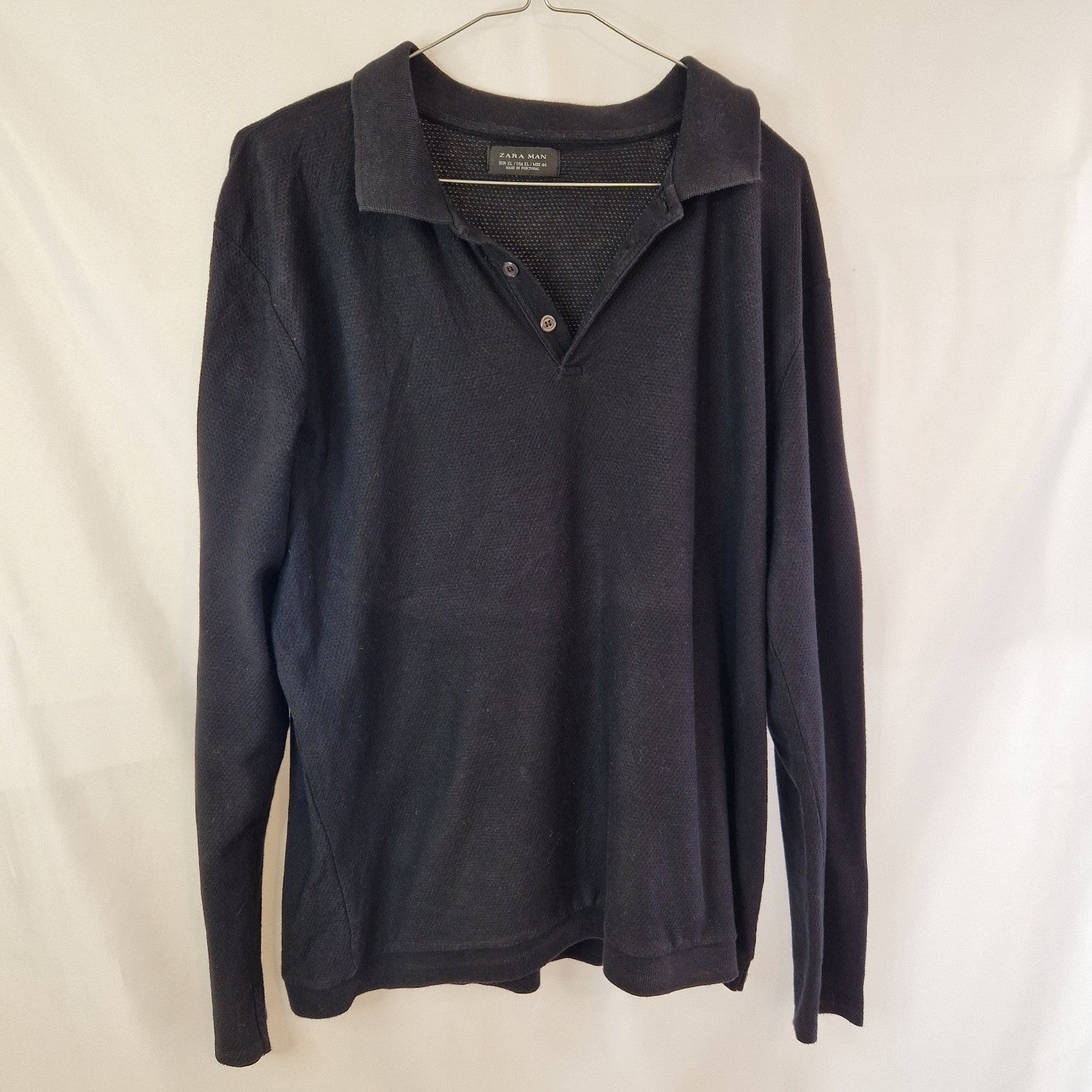 A black long-sleeve Zara Man knit sweater with a collared polo neckline and two buttons.