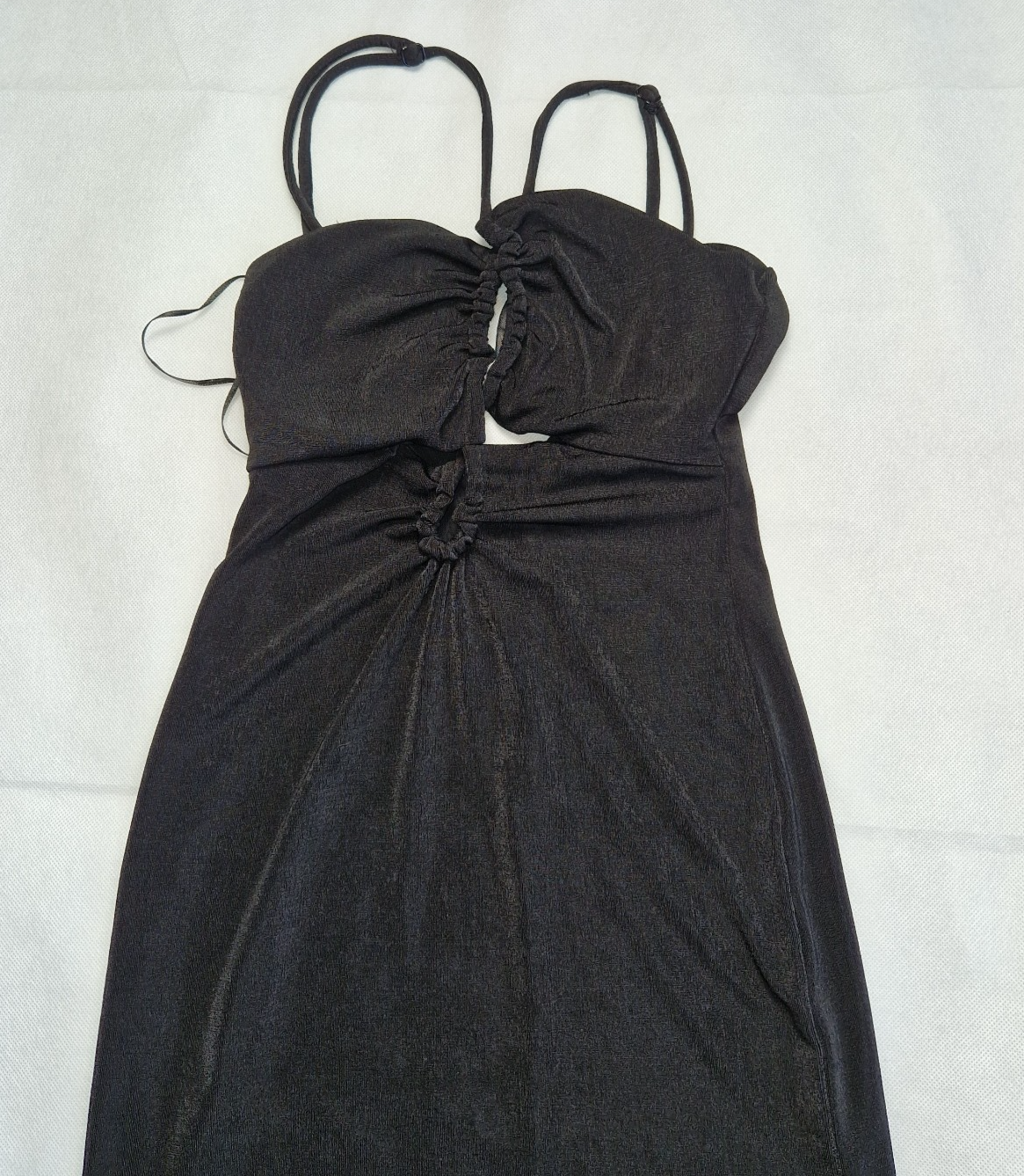 A black Bershka off-shoulder crop top with thin straps and gathered detailing.