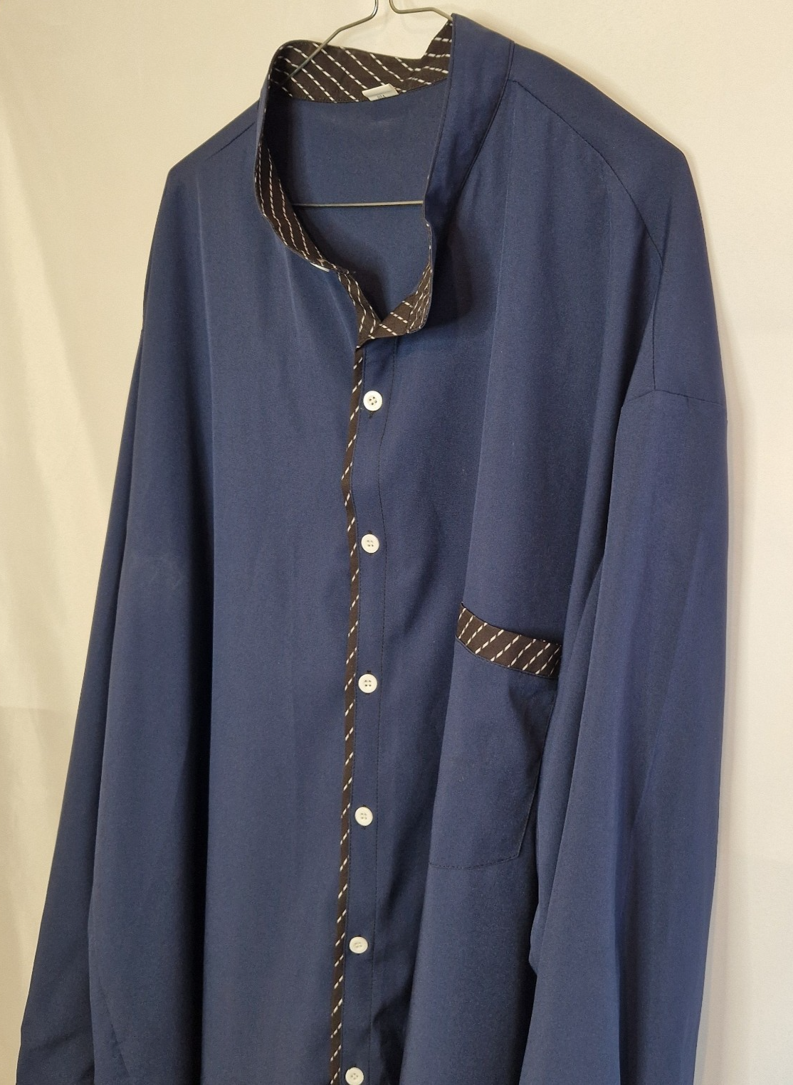 A blue long-sleeve shirt with a mandarin collar and brown patterned contrast trim.