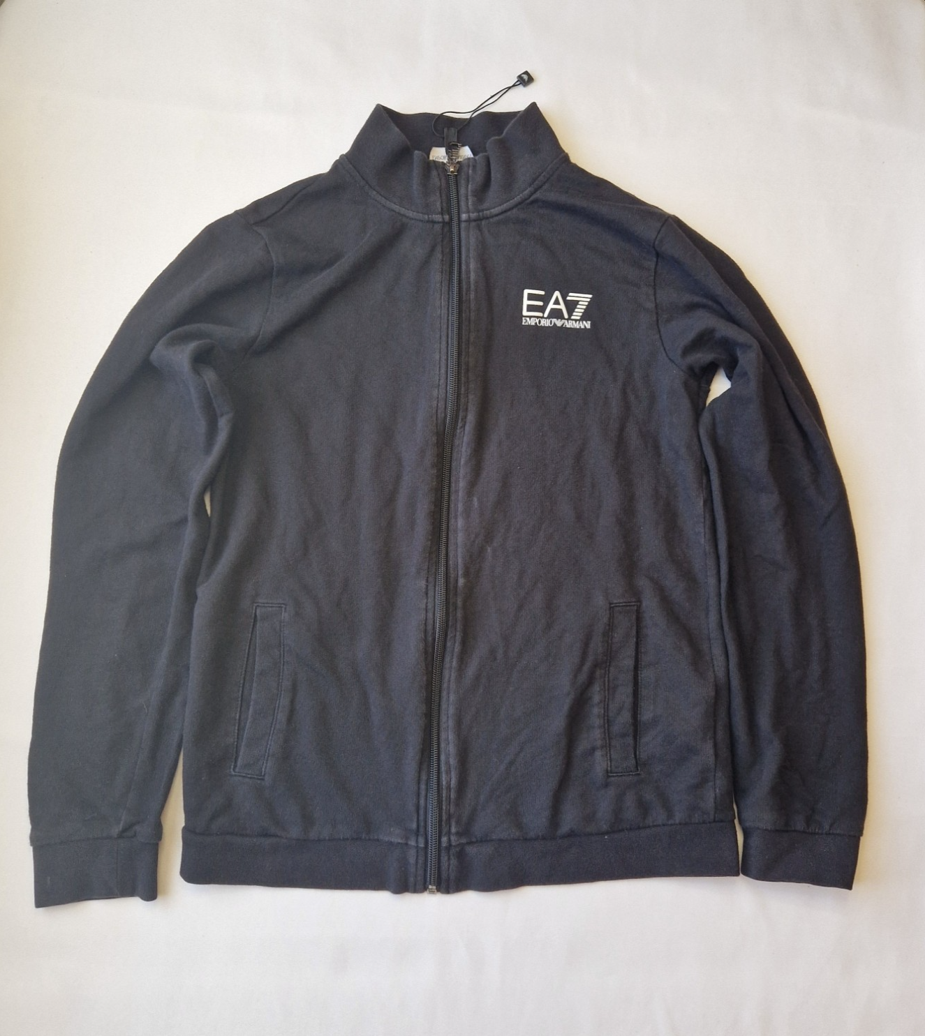 A black EA7 Emporio Armani junior zip-up bomber jacket with a stand-up collar and logo branding.