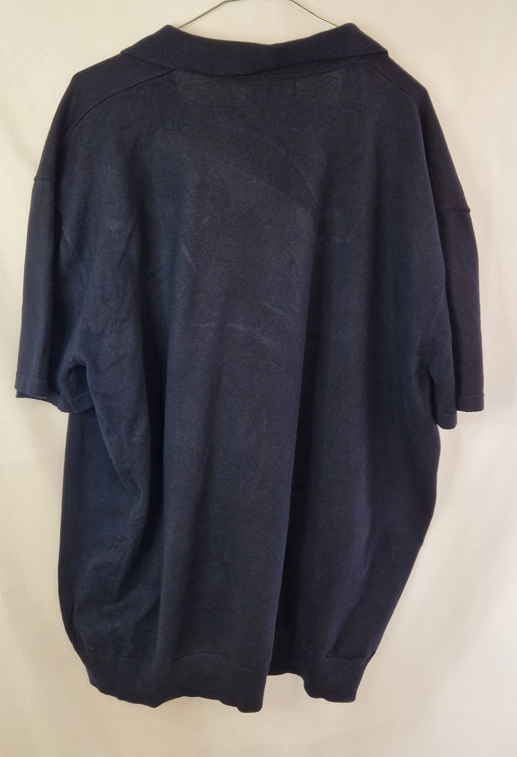 A dark blue Next men's short-sleeve cotton polo shirt with a V-neck collar.