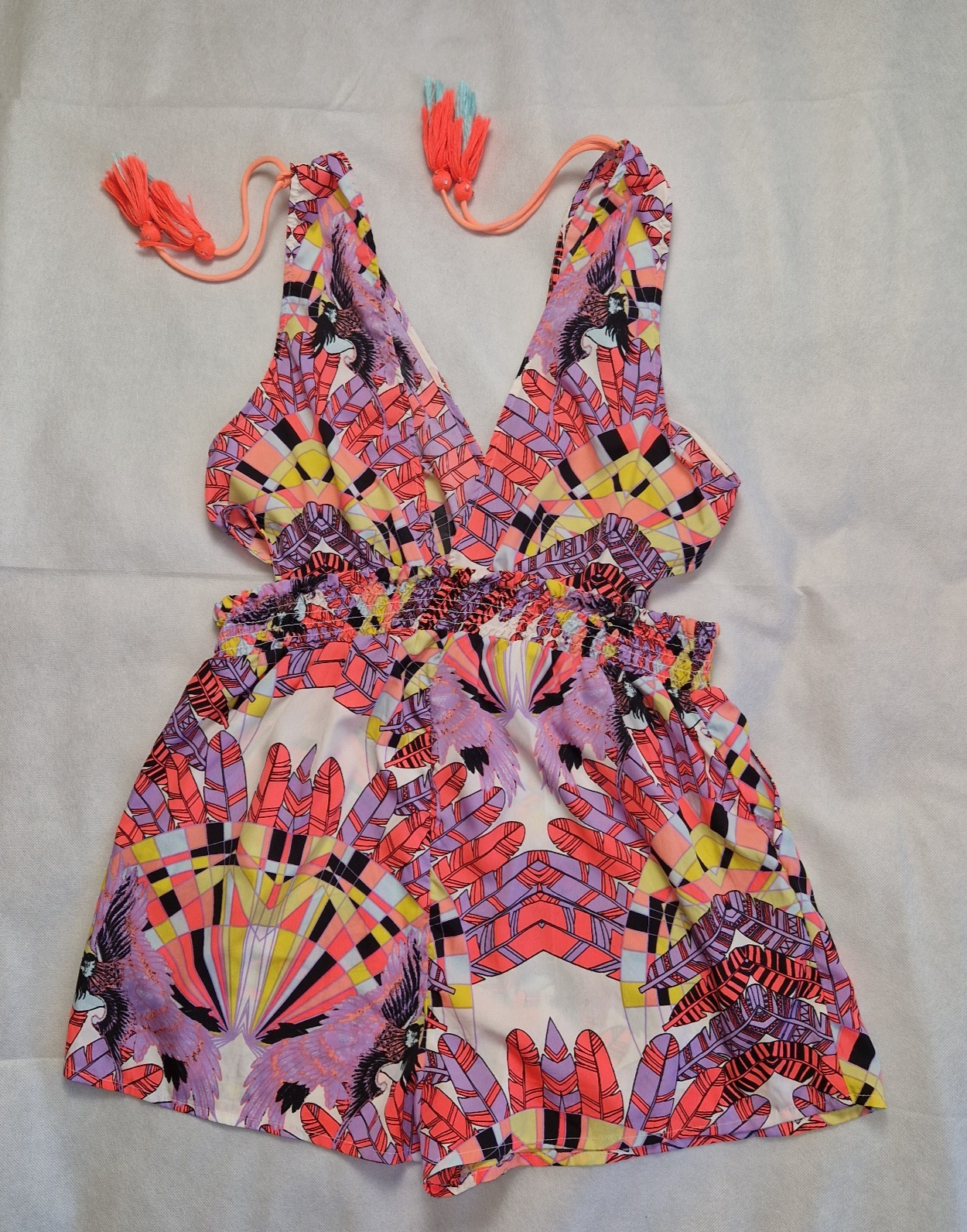 A multicoloured floral print playsuit with a V-neckline, tassel ties, and an elasticated waist.