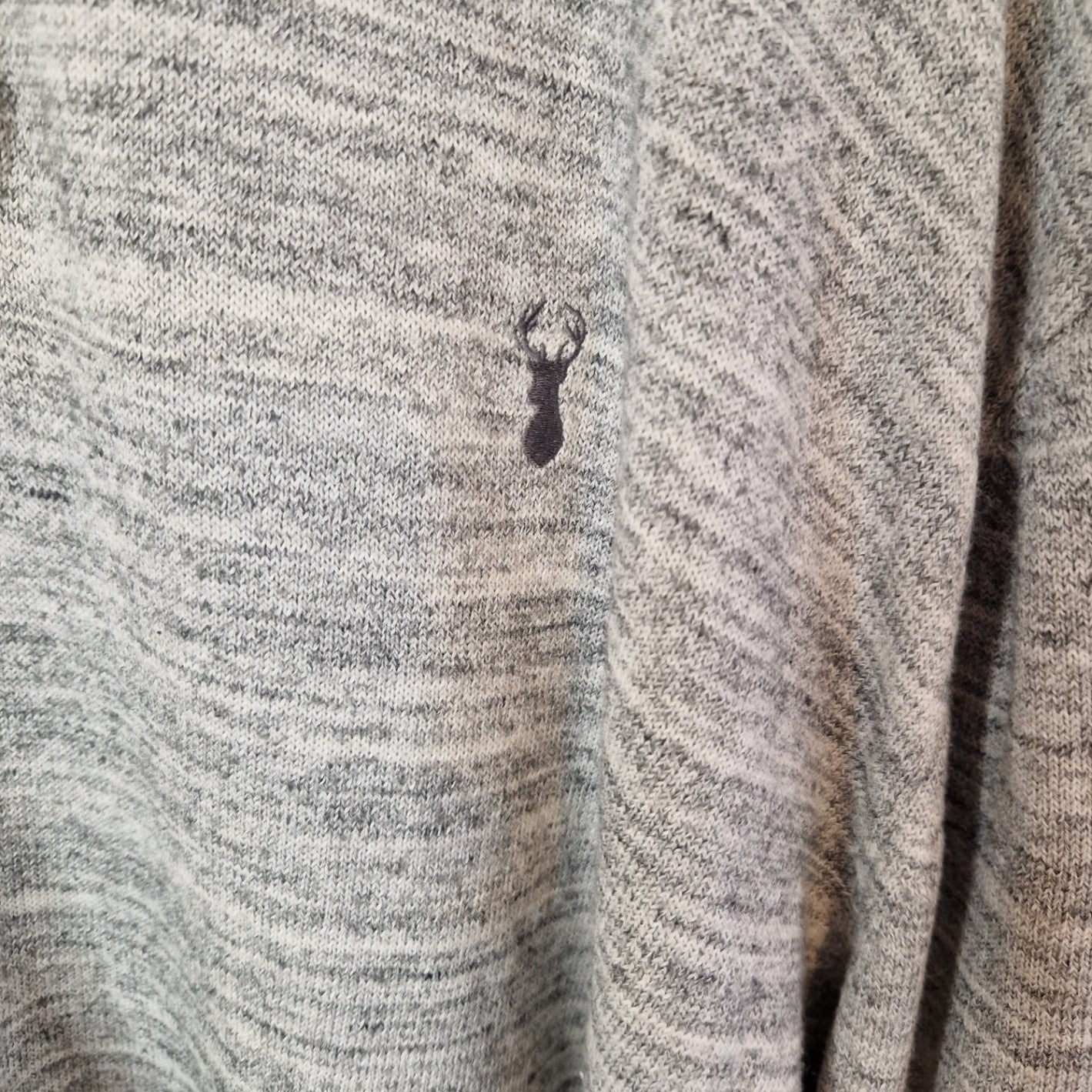 A grey knit quarter-zip pullover featuring a small embroidered stag logo on the chest.