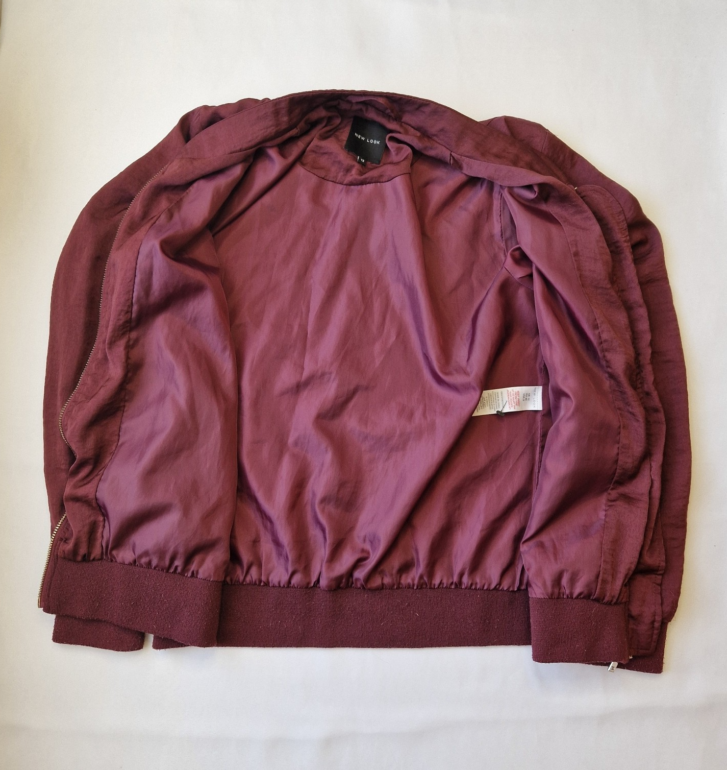A maroon New Look women's lightweight bomber jacket with a full zip and ribbed hem.
