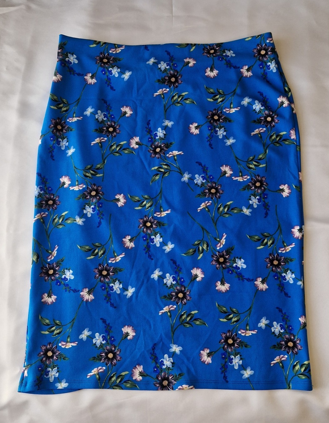 A blue knee-length wrap skirt featuring a floral print in a stretch jersey fabric.