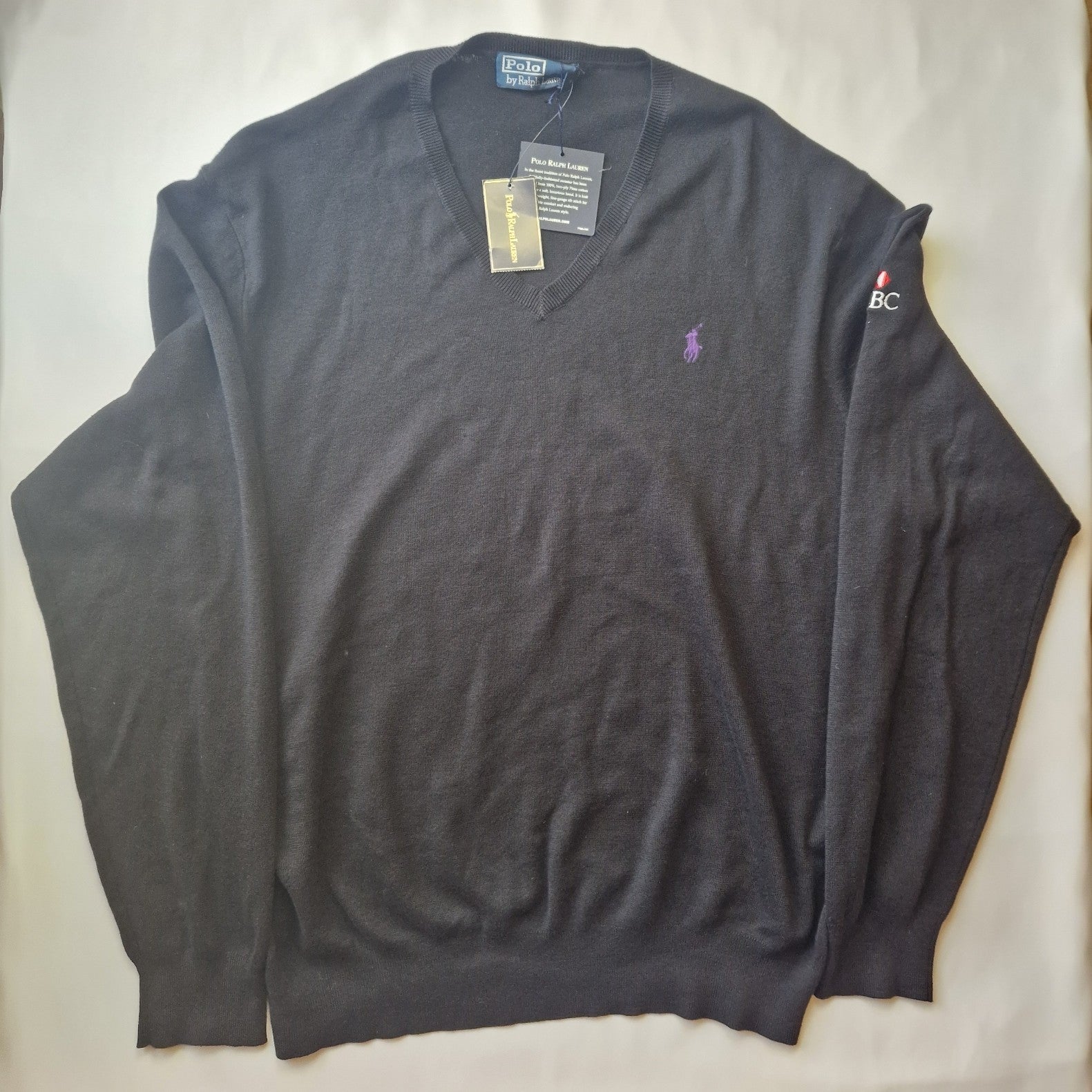 A black Polo Ralph Lauren V-neck cotton sweater featuring an embroidered HSBC logo on the sleeve.