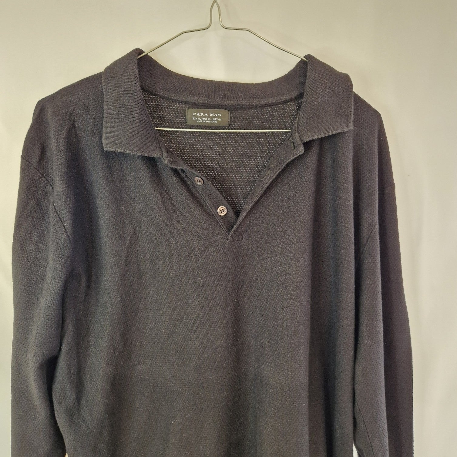 A black Zara Man long-sleeve knit polo sweater with a buttoned placket.