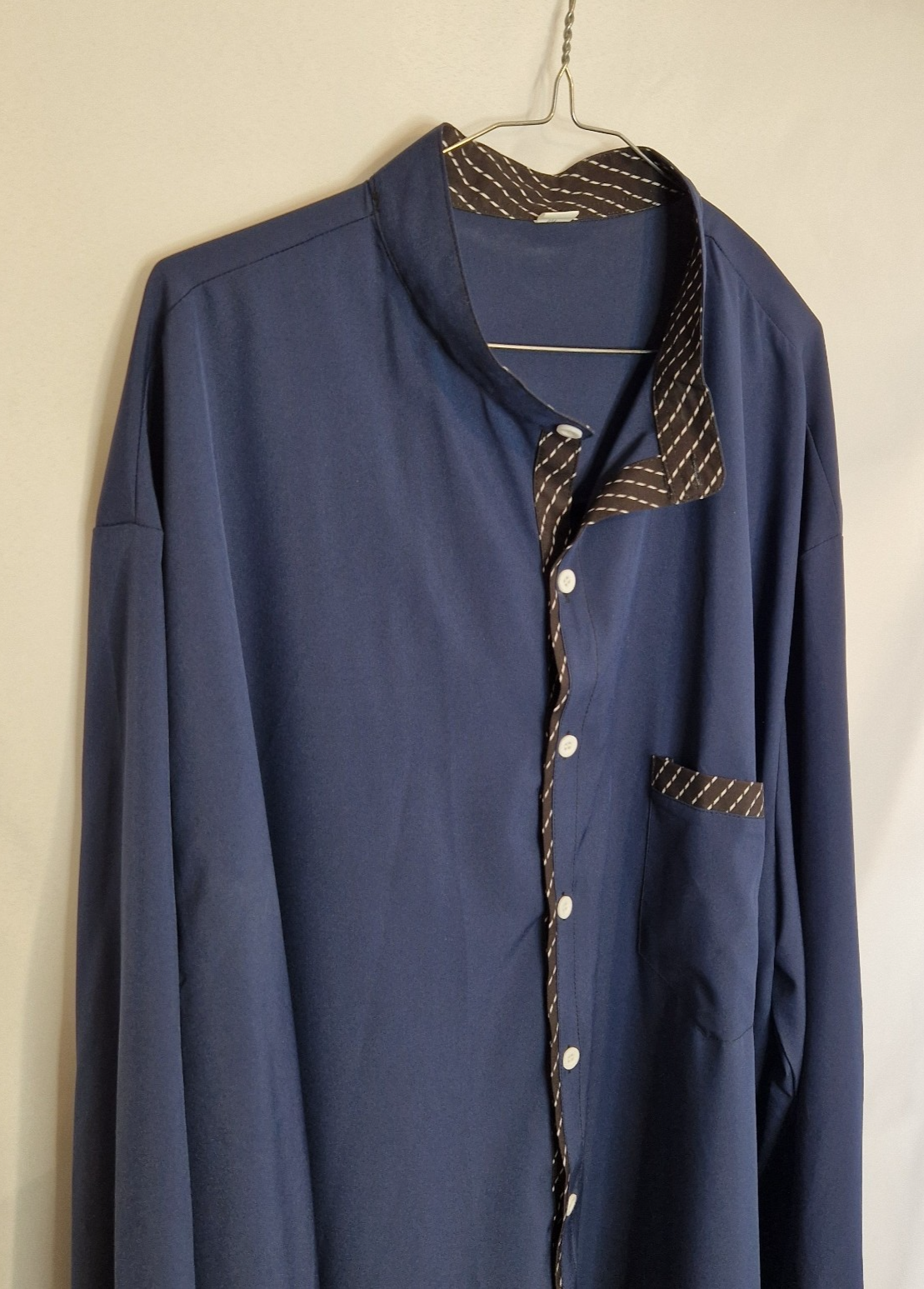 A blue long-sleeve satin shirt featuring a brown patterned contrast trim and white buttons.