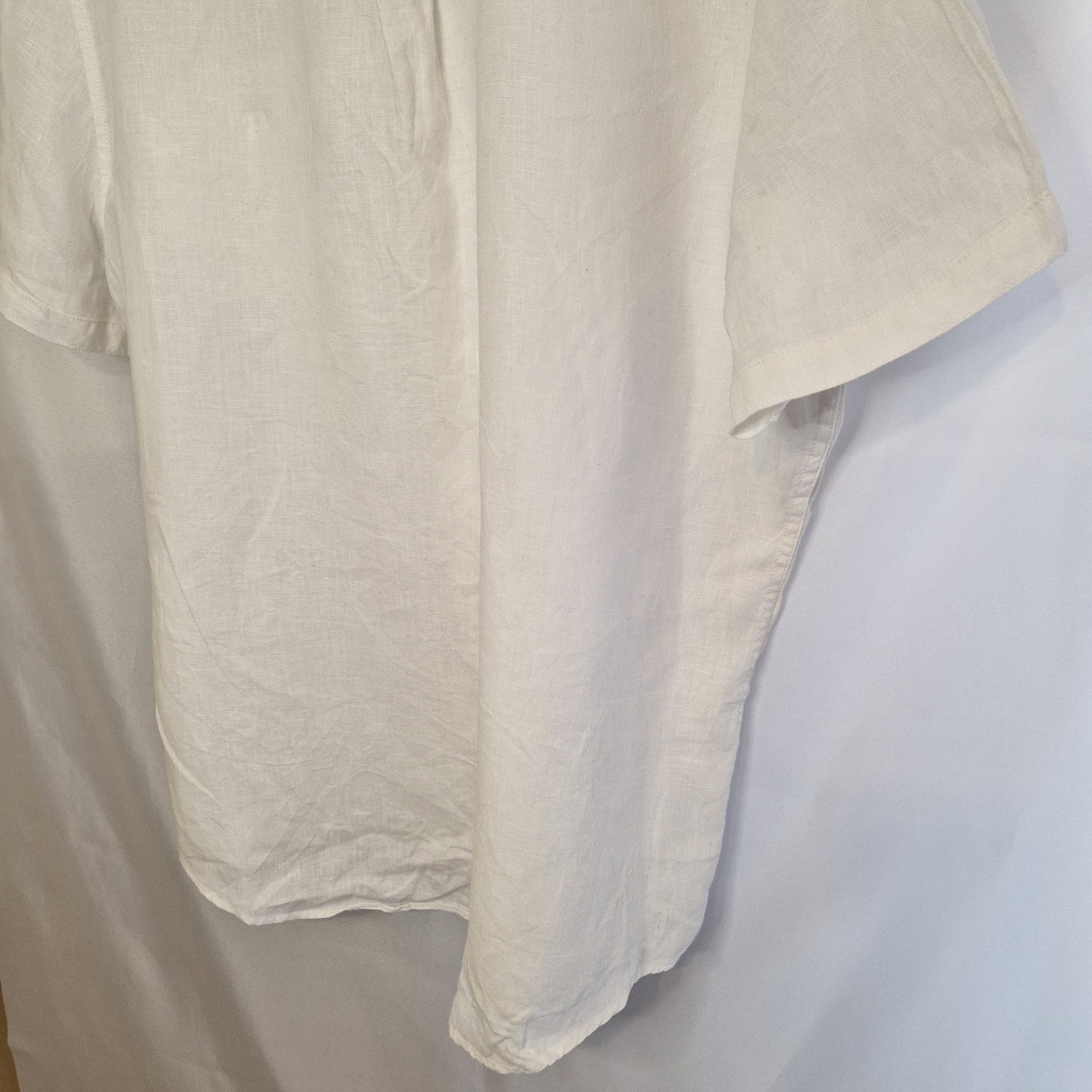A white short-sleeved button-down shirt with a blue floral print.
