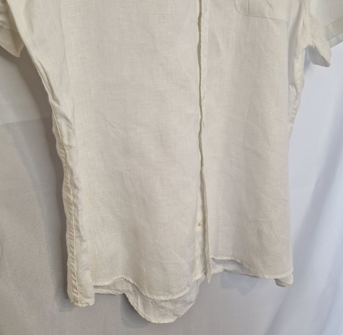 A white short-sleeved button-down shirt with a subtle blue floral print.