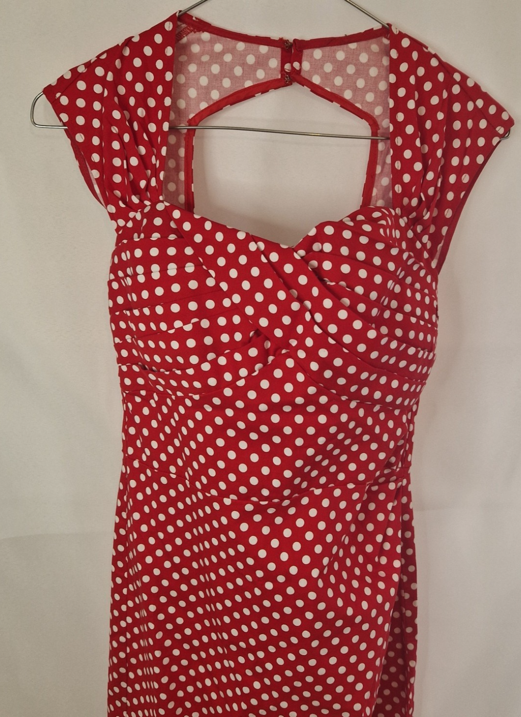 A red and white polka dot vintage-style halter dress with a fitted bodice and flared skirt.