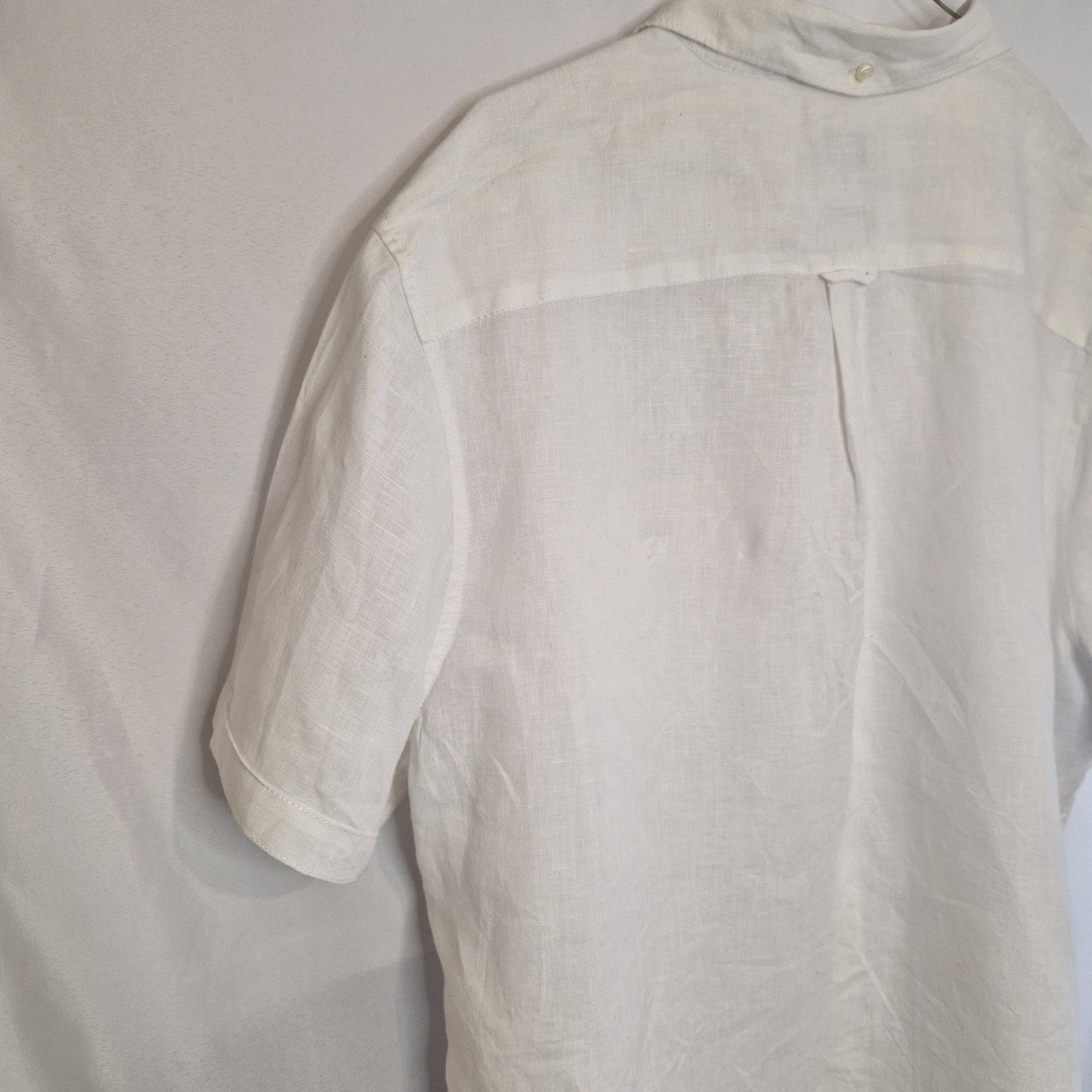 A white short-sleeved button-down shirt with a blue floral print.