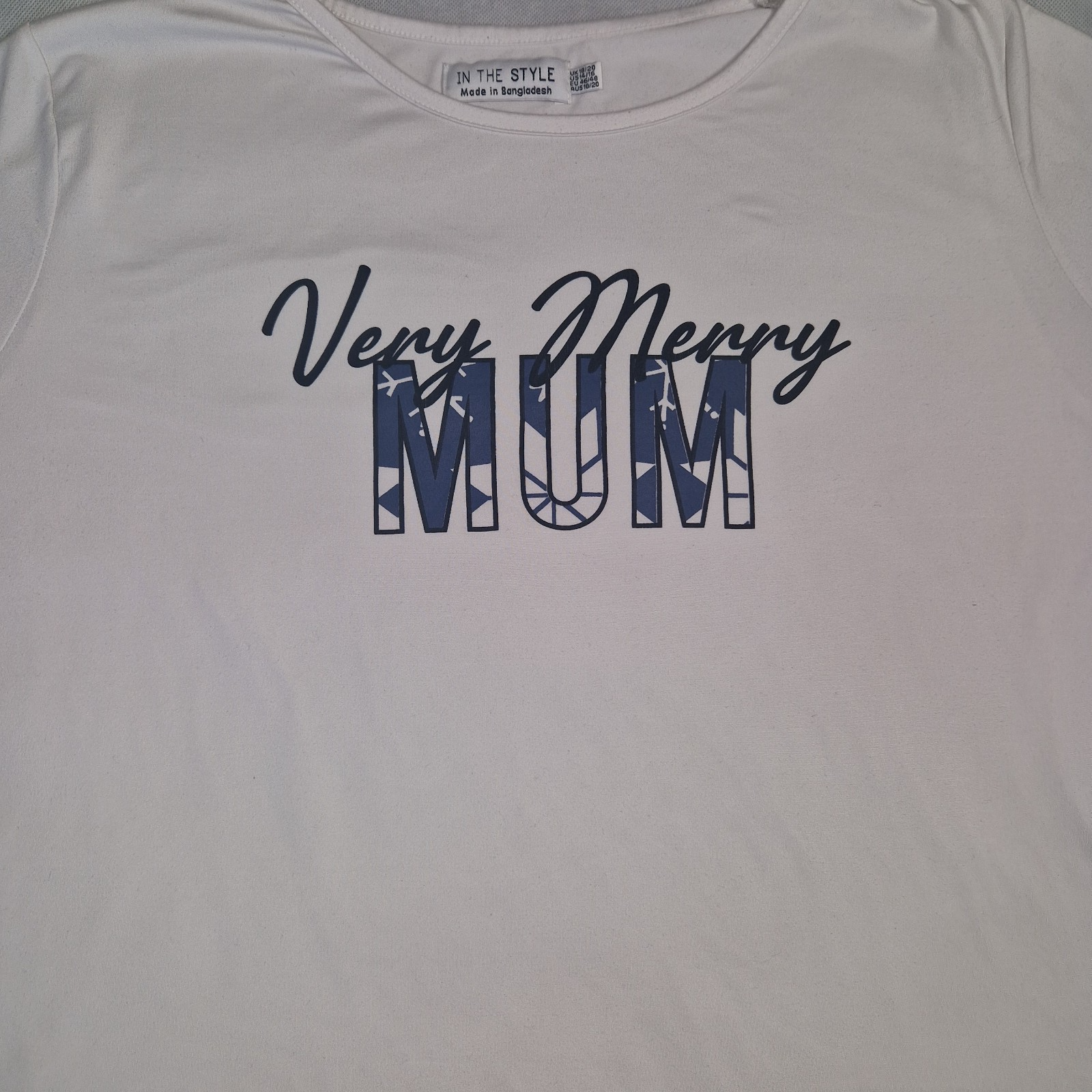 A white short-sleeved cotton t-shirt featuring the text Very Merry MUM in navy blue.