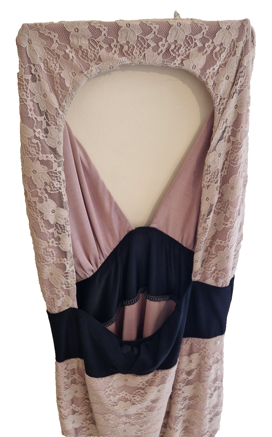 A pink lace ball gown featuring a halter neckline, black waist detailing, and cut-out accents.